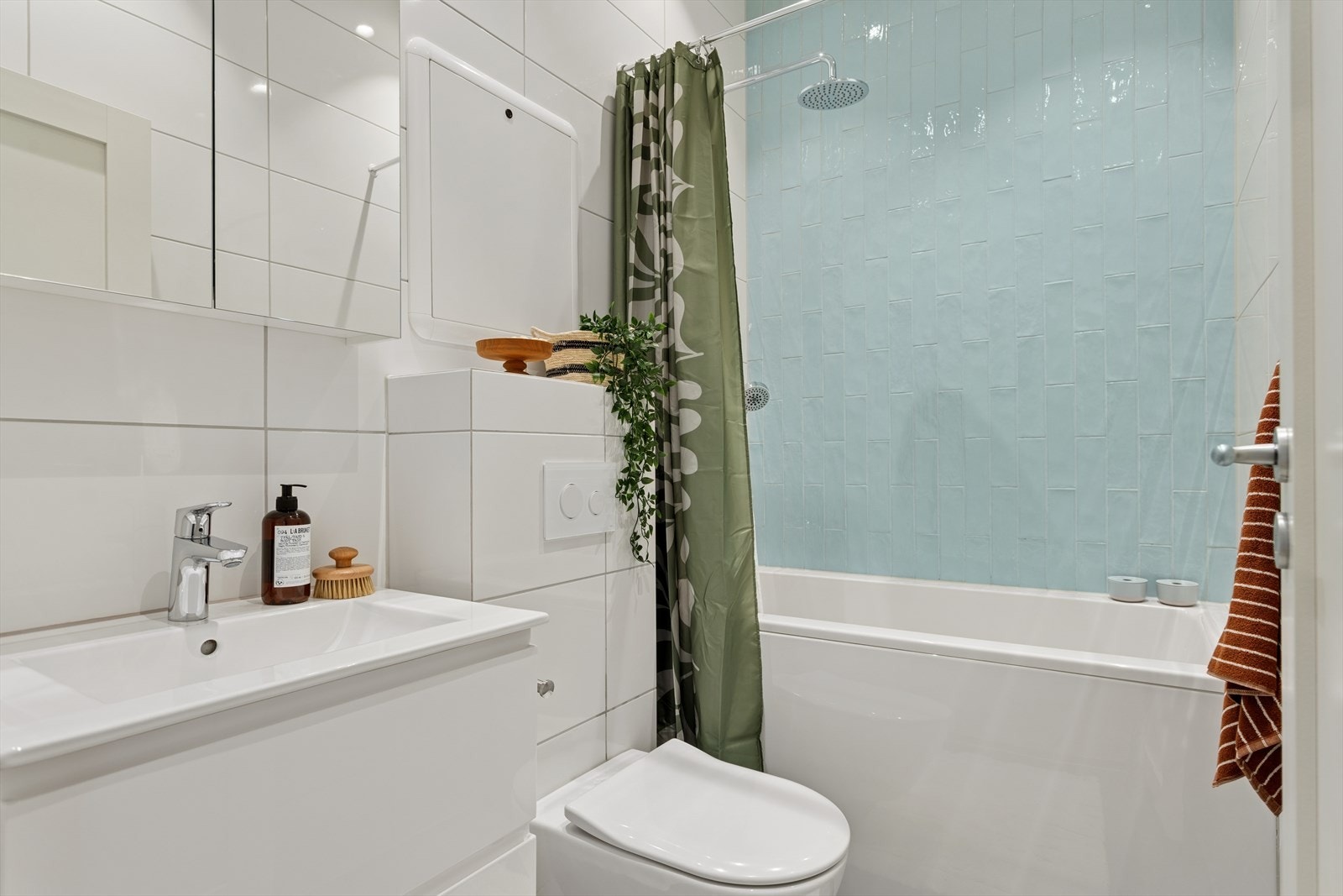 Delikat og moderne bad fra 2022 med flislagte gulv med varme under og vegger i lyse, tidsriktige farger. Galleribilde