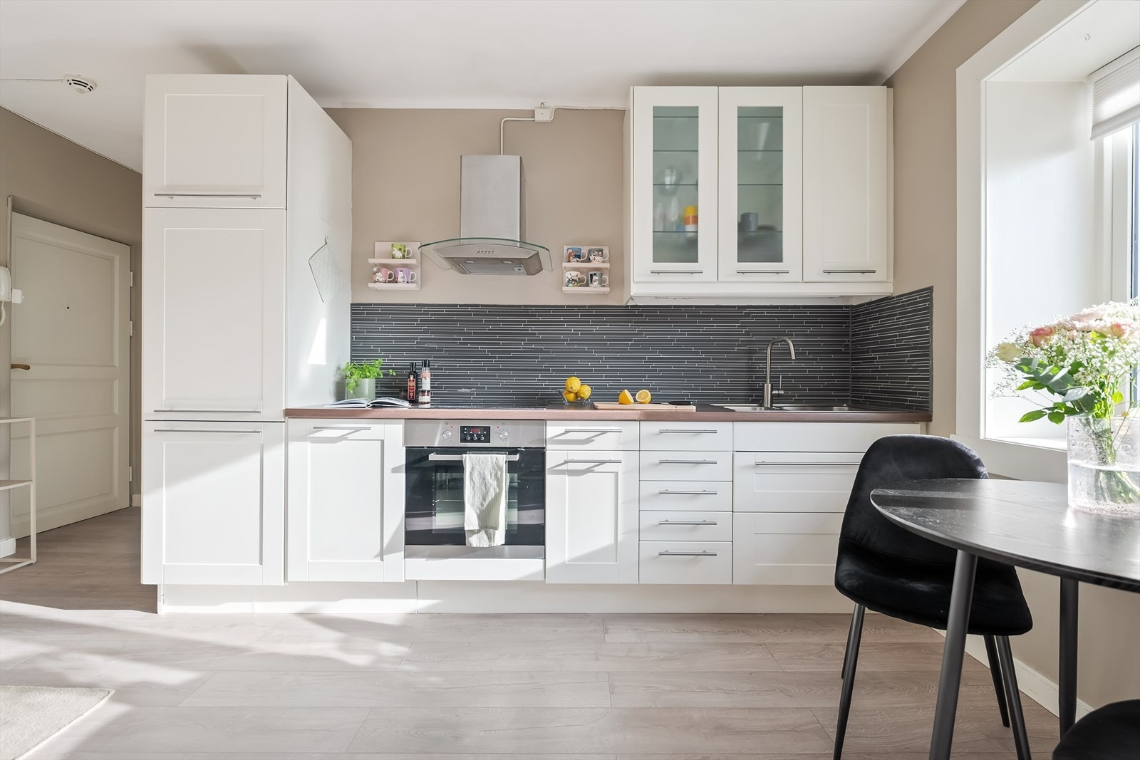 Benkeplaten på kjøkkenet er av laminat med nedfelt oppvaskkum i rustfritt stål. Over benken er det fliser på vegg, og ventilator med kullfilter. Kjøkkenet er utstyrt med integrert platetopp, stekeovn og kjøl-/fryseskap. Galleribilde