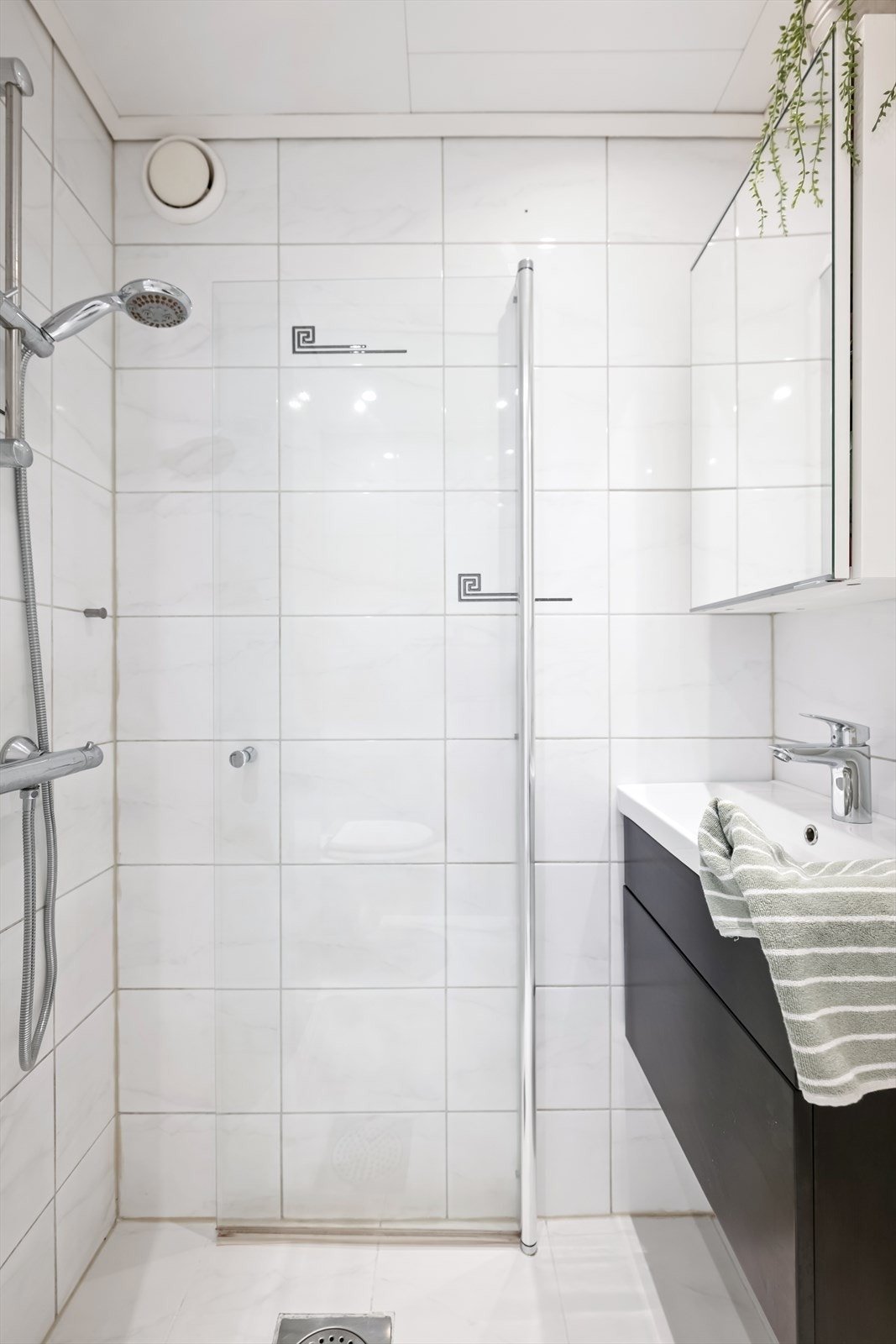 Innredningen består av servant med heldekkende vask på underskap med folierte fronter, i tillegg til praktisk speilskap som gir gode oppbevaringsmuligheter. Galleribilde