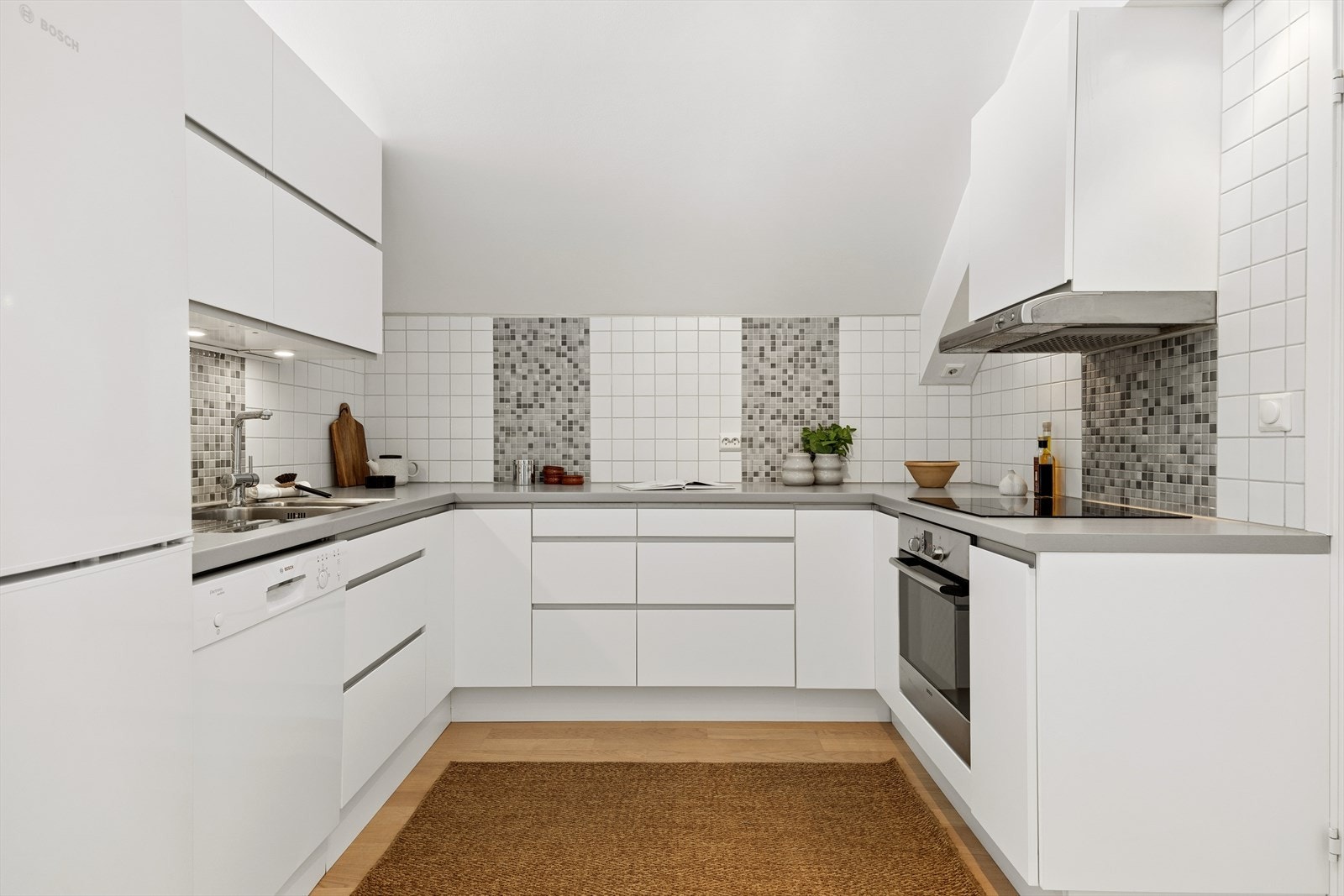 Stilren kjøkkeninnredning med glatte fronter og laminat benkeplate. Galleribilde