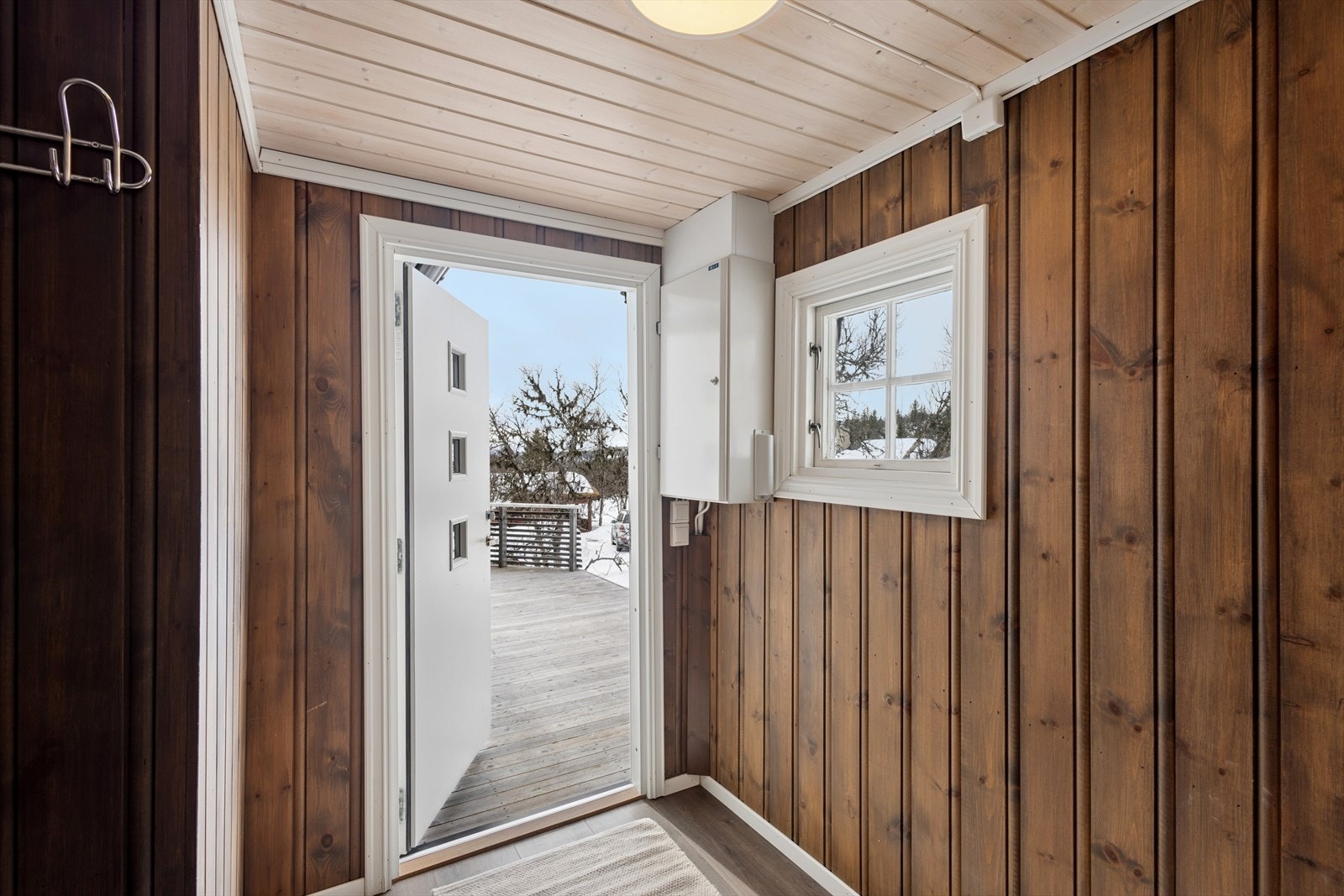 Inngangspartiet har panelte vegger og en ytterdør med isolerglass. Galleribilde