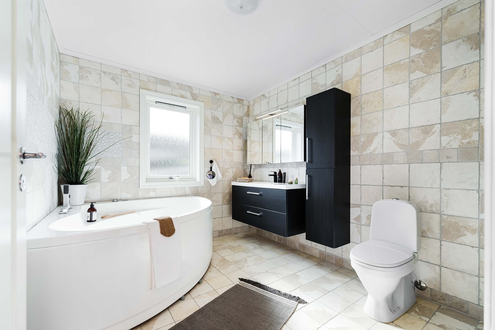 Pent og delikat bad med både badekar, dusj, toalett og baderomsmøblering Galleribilde