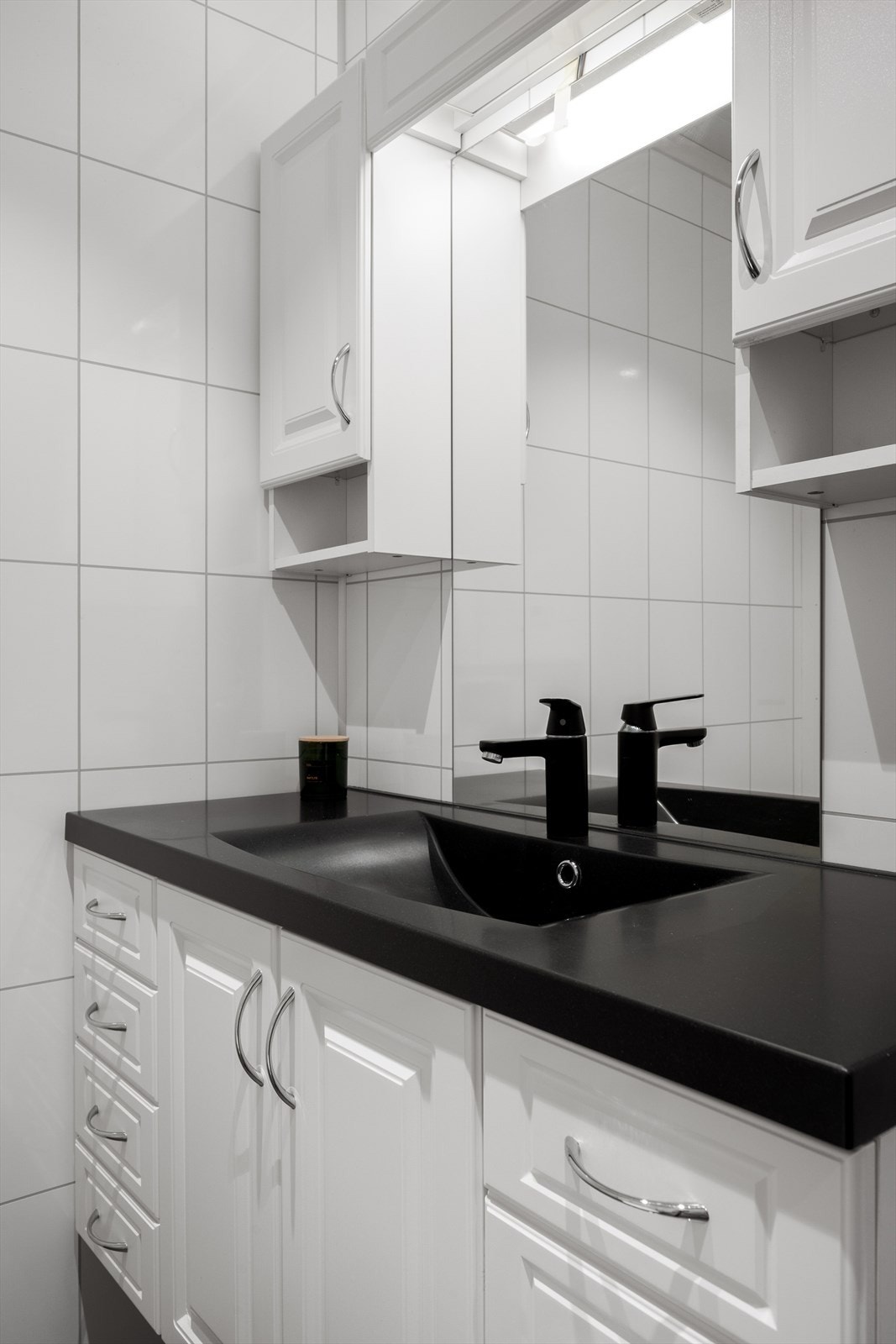 Baderomsinnredningen har en stilren servant og god oppbevaringsplass i skuffer og skap. Galleribilde