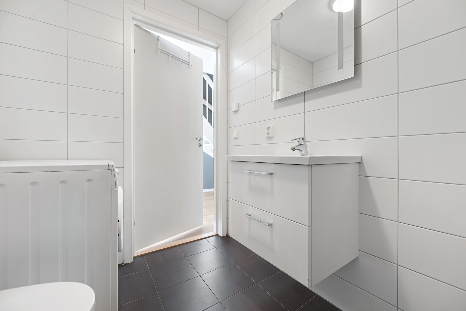 Badet fremstår pent og praktisk, med fliser på vegger og gulv samt malt tak. Galleribilde