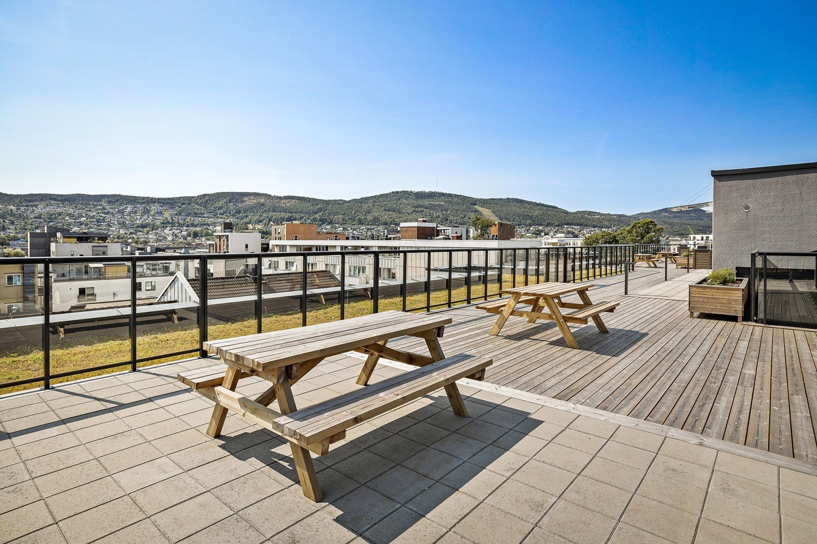 Beboerne har tilgang til romslig felles takterrasse med sittebenker og hyggelig bakgård med felles sykkelparkering (låst sykkelbod) samt lekeplass med lekeapparater - Sommerbilde fra tidligere annonse Galleribilde