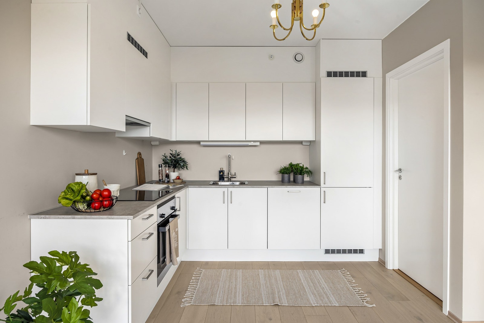 Kjøkkeninnredning med hvite og glatte fronter og benkeplate med laminert overflate Galleribilde