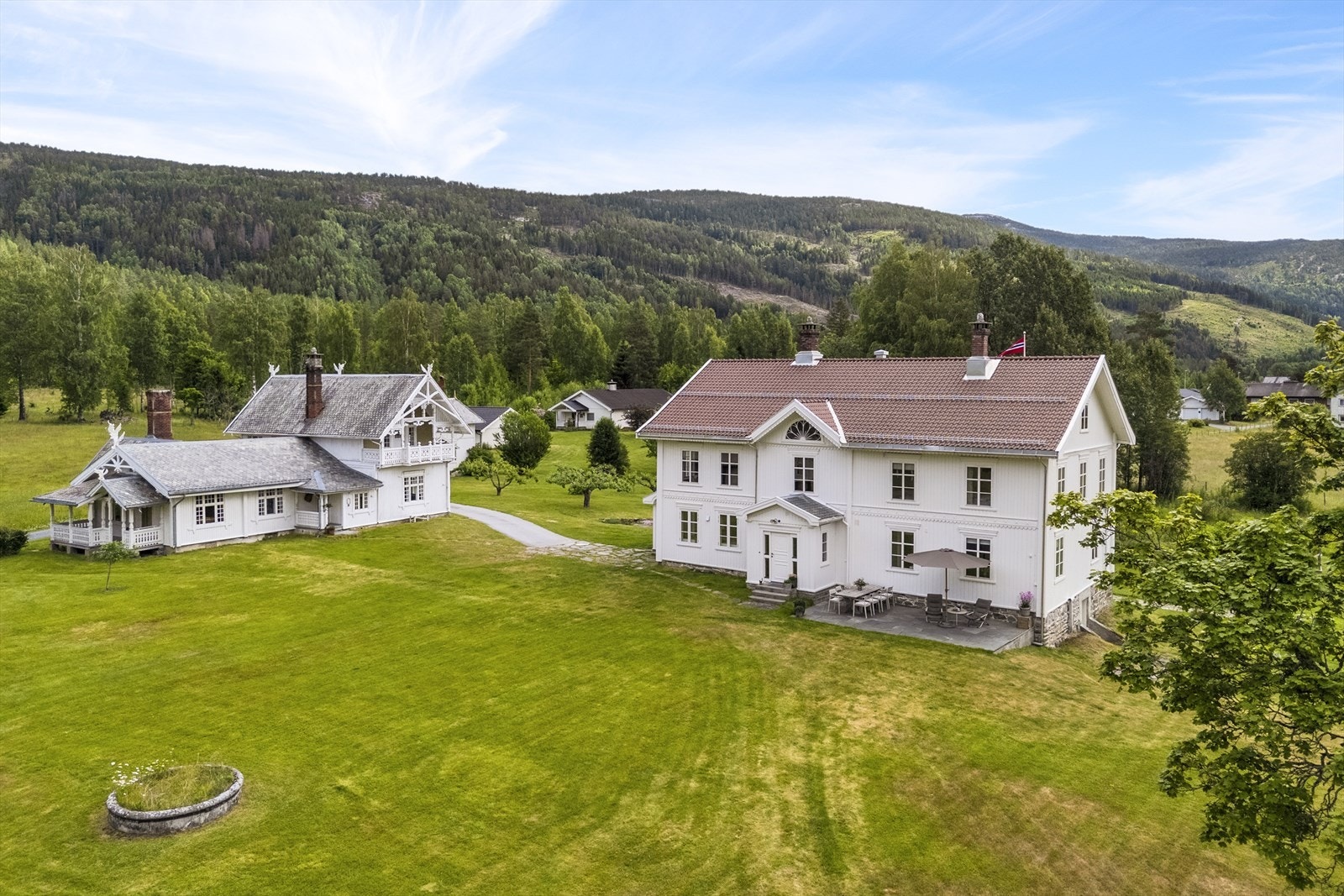 Tunet ligger ned mot elva og innehar en stor bygningsmasse som hovedbygning, hallingstue, driftsbygning, drengestue, 2 stabbur og vognskjul Galleribilde