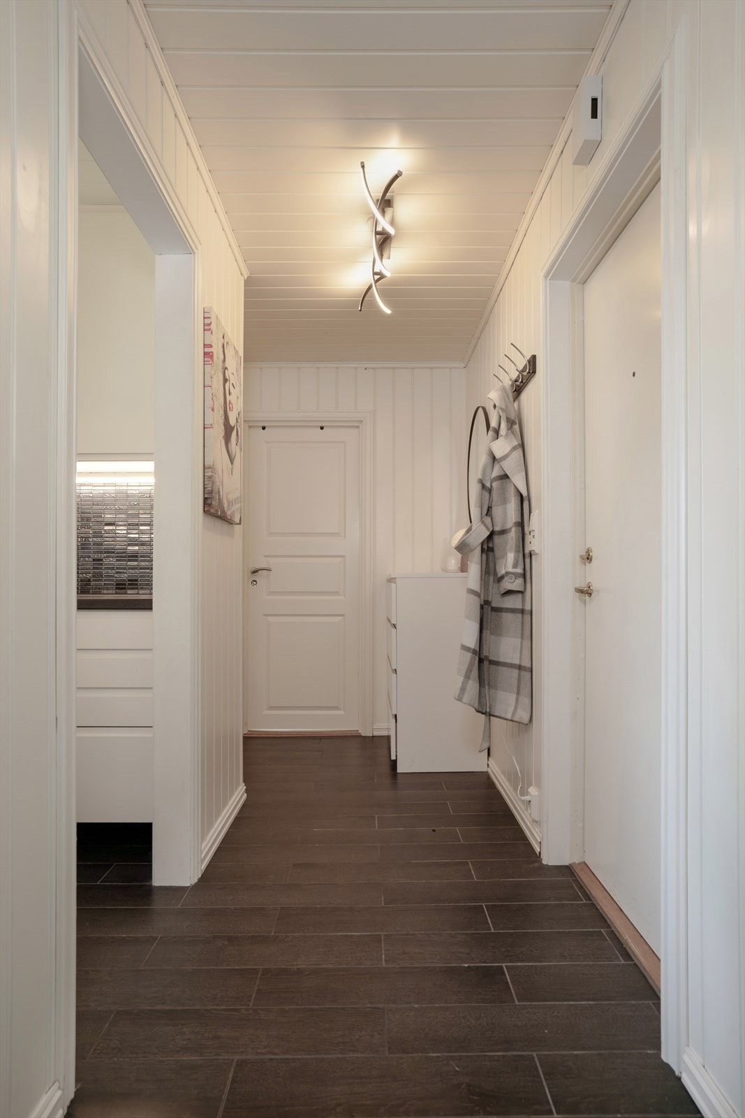 Boligen har laminat og fliser på gulv, med malte MDF-plater på vegger og MDF-panel i himling. Galleribilde