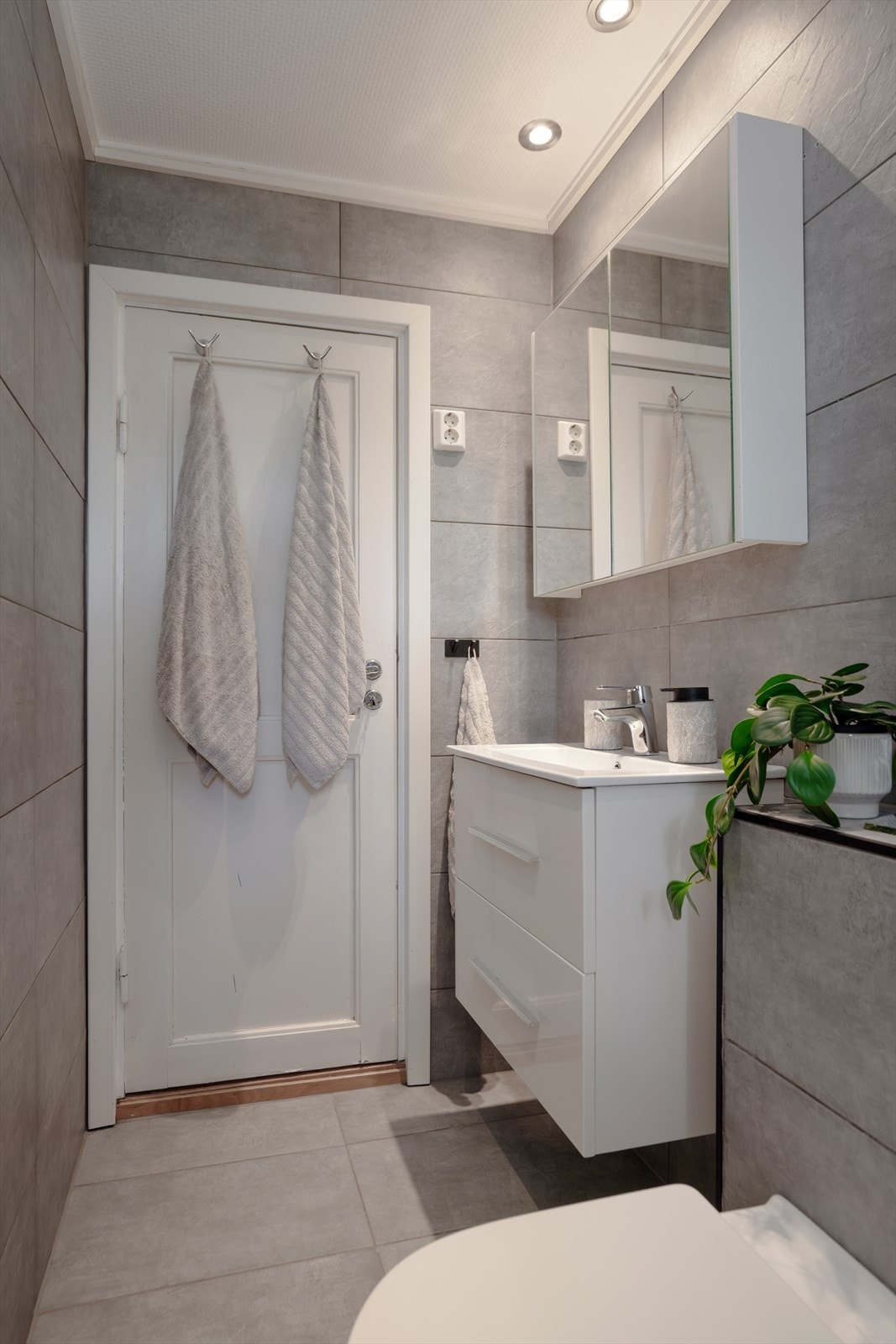 Badet er innredet med servant med innredning, vegghengt toalett og dusjhjørne med dusjvegger. Galleribilde