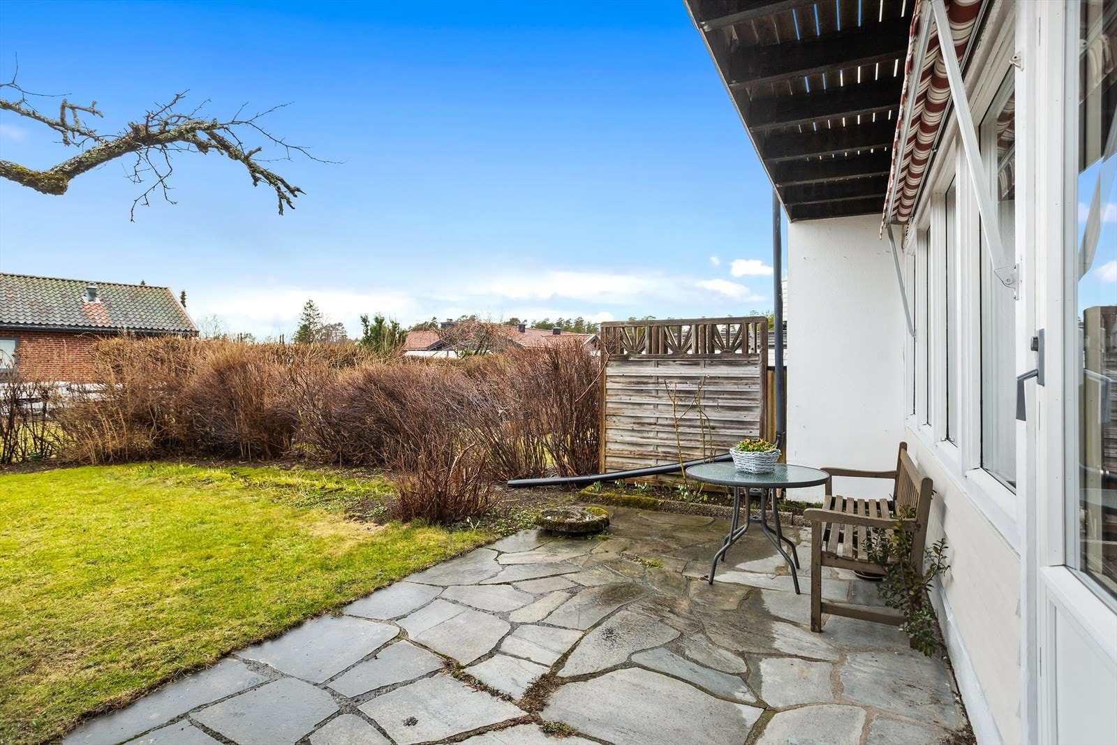 Den steinlagte uteplassen gir en lun og hyggelig uteplass med plass til utemøbler. Galleribilde