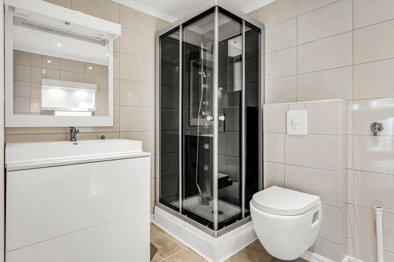 Badet er innredet med dusjkabinett, vegghengt toalett og gulvvarme. Galleribilde