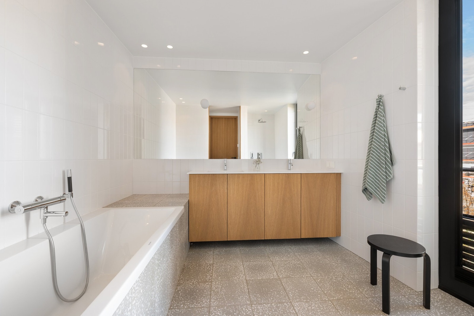 Moderne baderom med flislagt gulv med vannbåren gulvvarme og vegger i våtsoner. Galleribilde