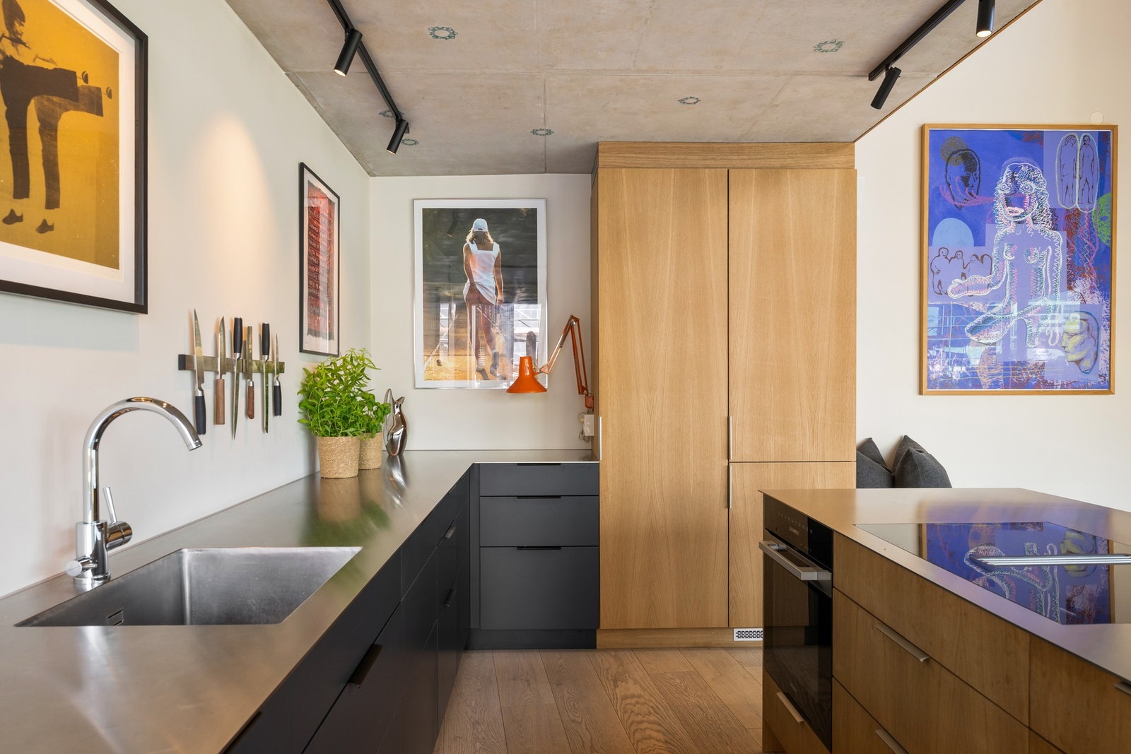 Hel benkeplate av rustfri stål med integrert vaskekum og nedfelt Mièle keramisk platetopp med integrert ventilator. Galleribilde