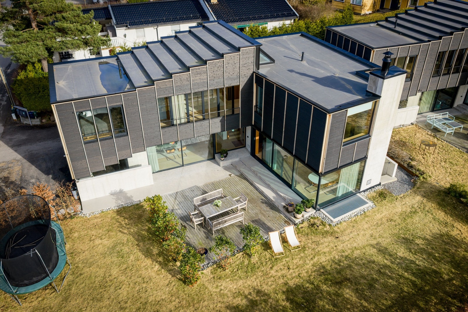 Pent opparbeidet gårdsplass, gressplen og annen beplantning, samt noe fjellgrunn mot øst Galleribilde