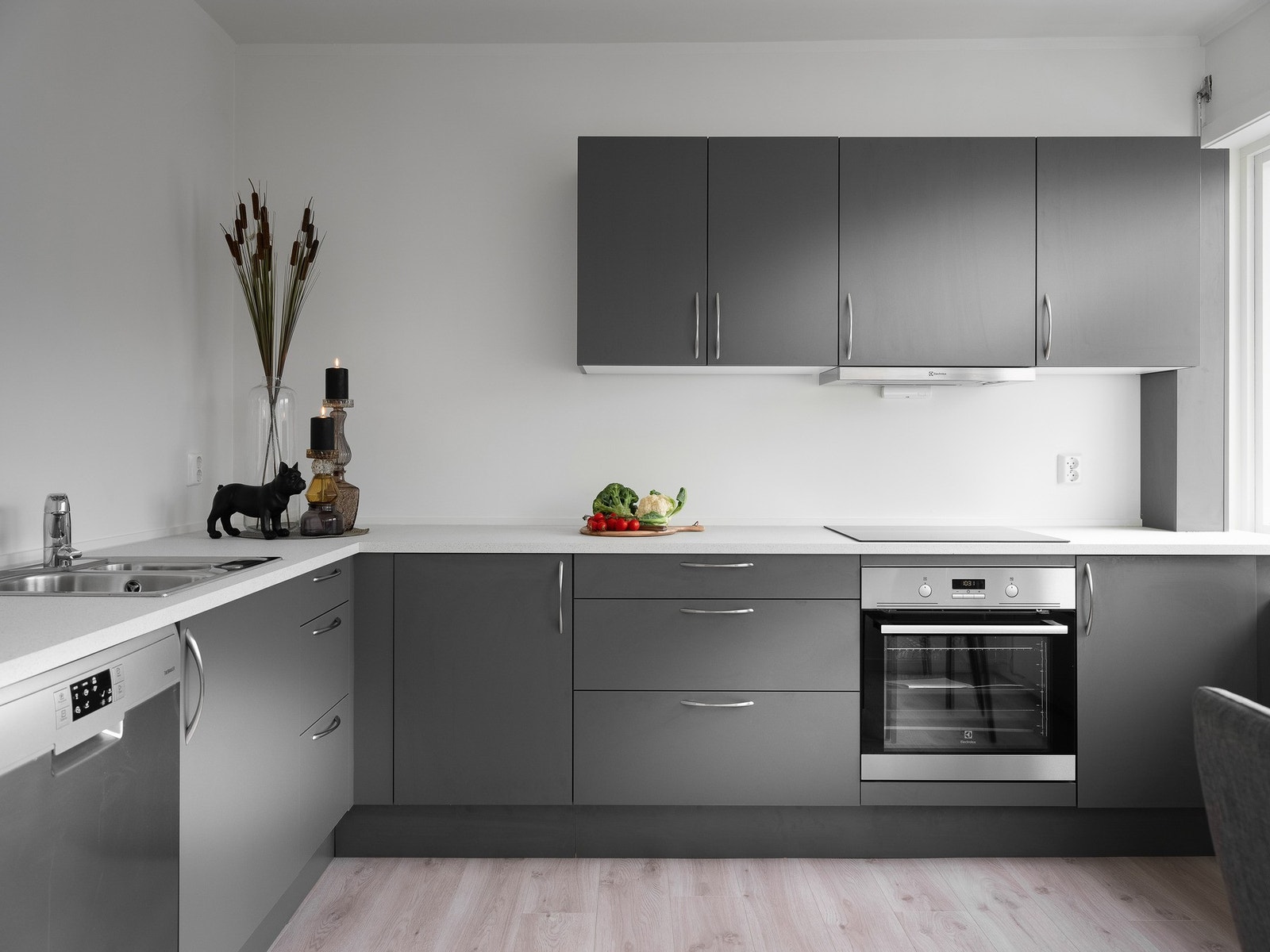 Kjøkkeninnredning med malte, glatte fronter og laminat benkeplate. Galleribilde