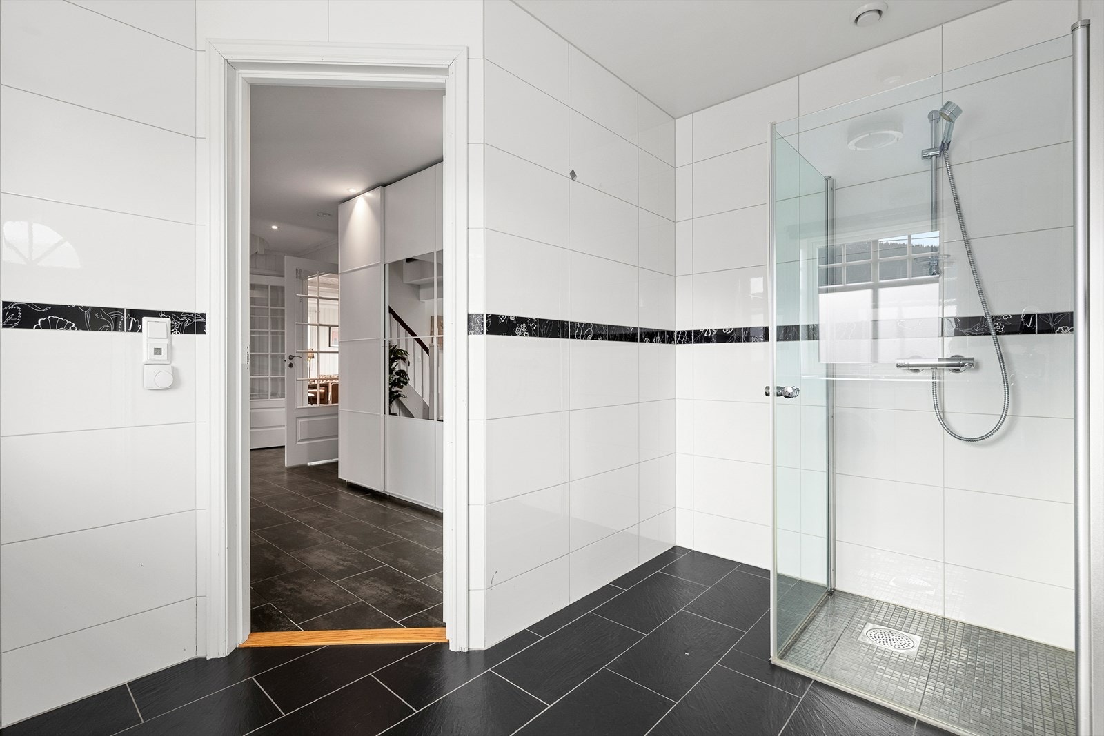 Badet er utstyrt med innfellbare dusjdører, opplegg for vaskemaskin og innredning med skyllekum Galleribilde