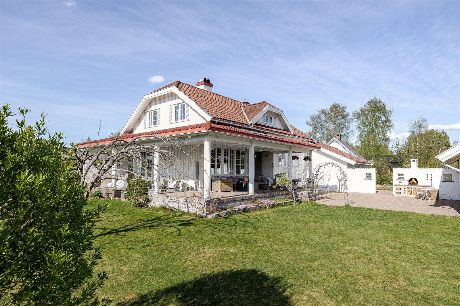 Terrassen ved inngangspartiet har et flott blomsterbed utenfor. Galleribilde
