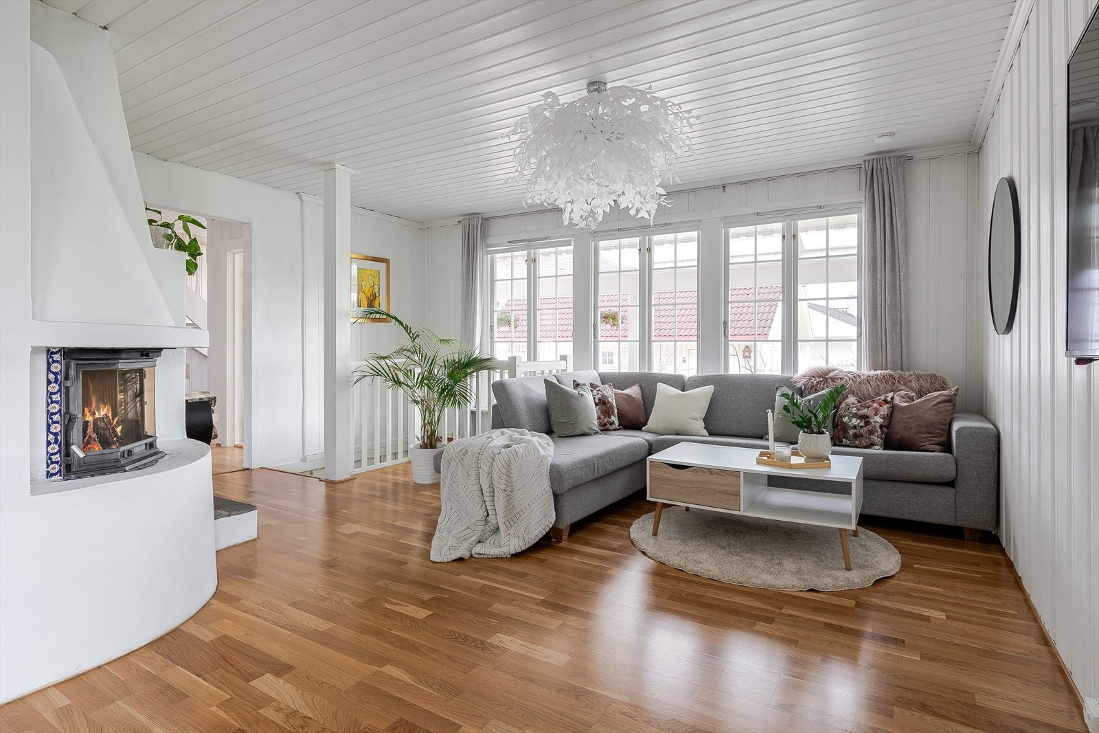 Lys og fin stue med flere store vindusflater ut mot det hyggelige inngangspartiet. Galleribilde