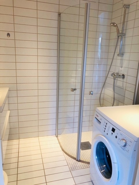 Badet i utleiedelen har servant på innredning, dusjhjørne og opplegg for vaskemaskin. Galleribilde