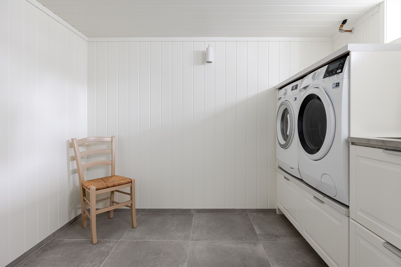 Rommet har store fliser på gulv, lyse panelplater på veggene og mekanisk avtrekk. Varmekabler i gulvet. Galleribilde