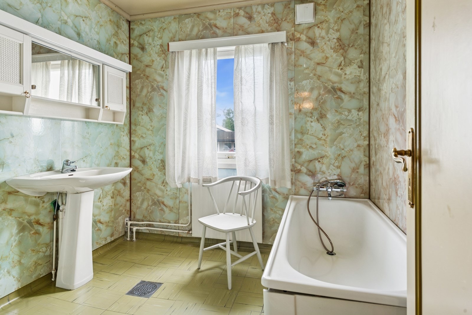 Bad i 1 etasje som er innredet med badekar, servant og toalett. Galleribilde