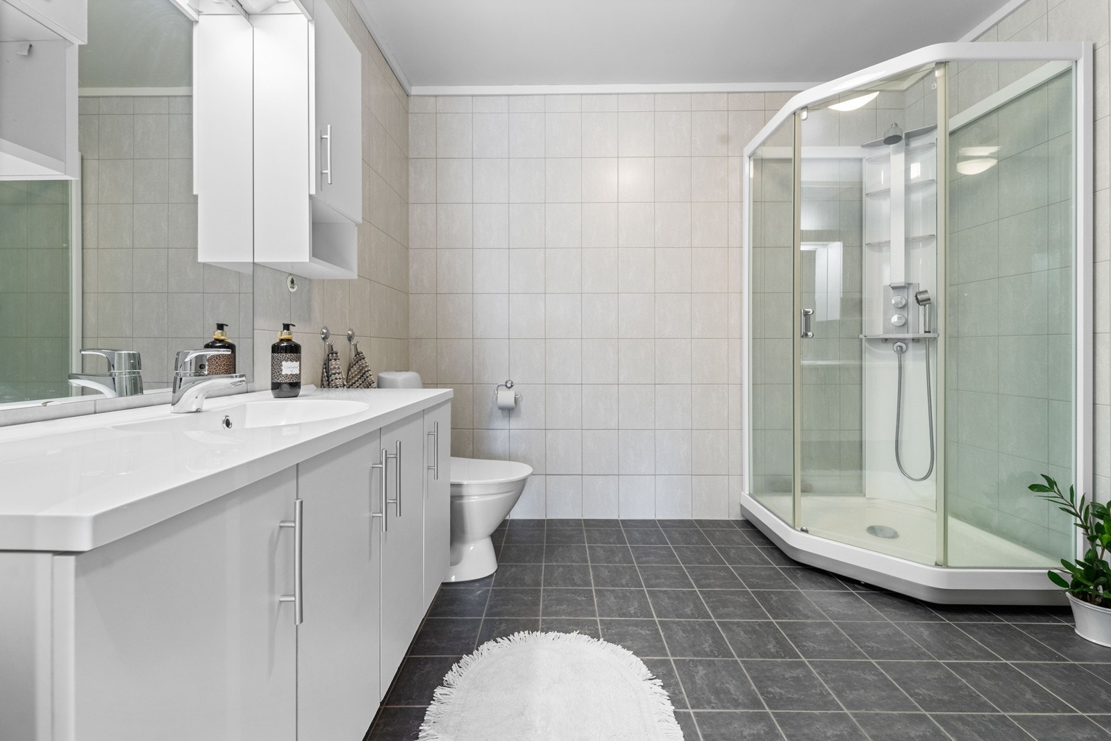 Romslig bad med dusjkabinett. Det er vaskerom også i leiligheten. Galleribilde