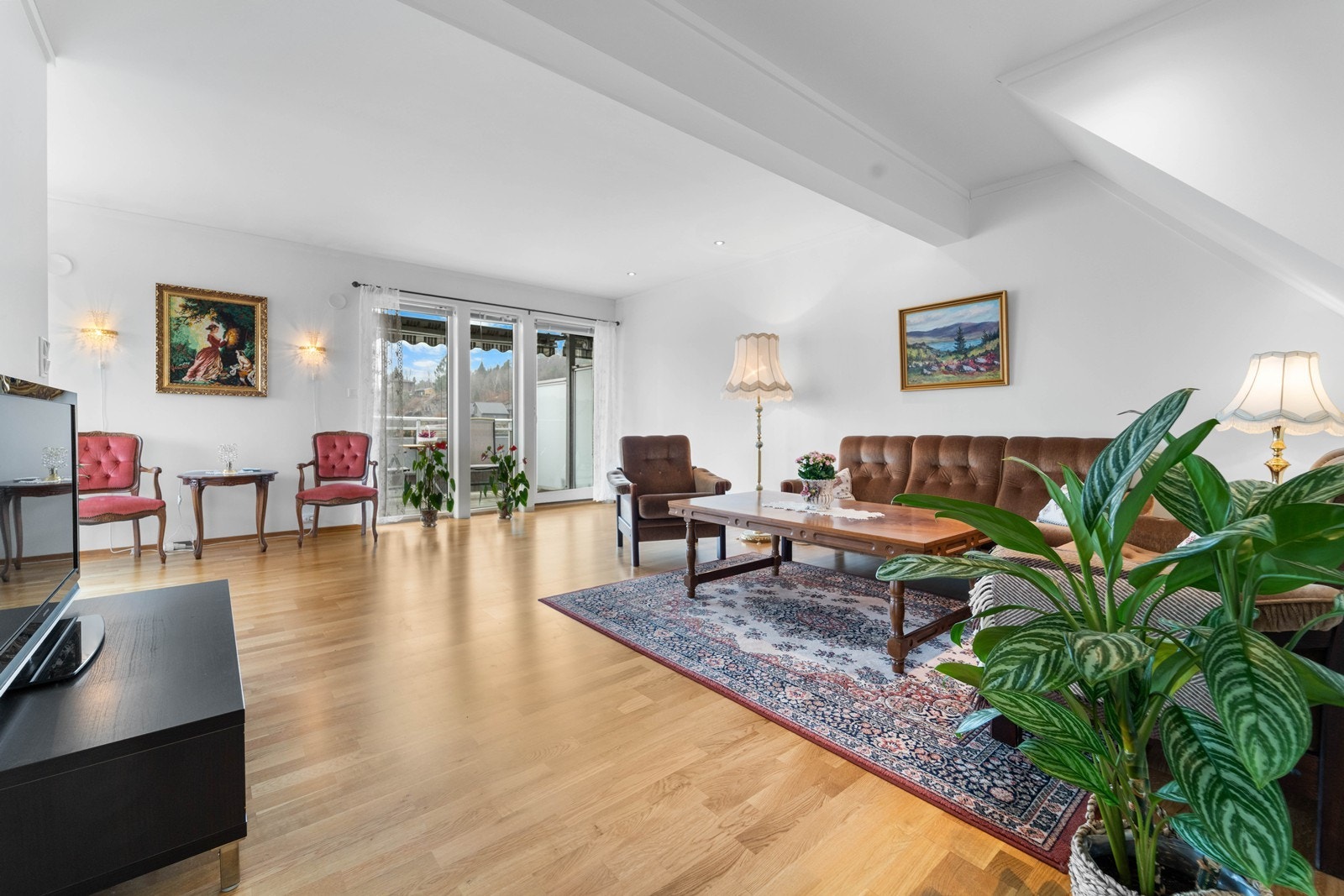 Romslig og lys stue med vestvendt utsikt. Kjøkkenet er på hjørnet av bygget mot sør og vest. Galleribilde