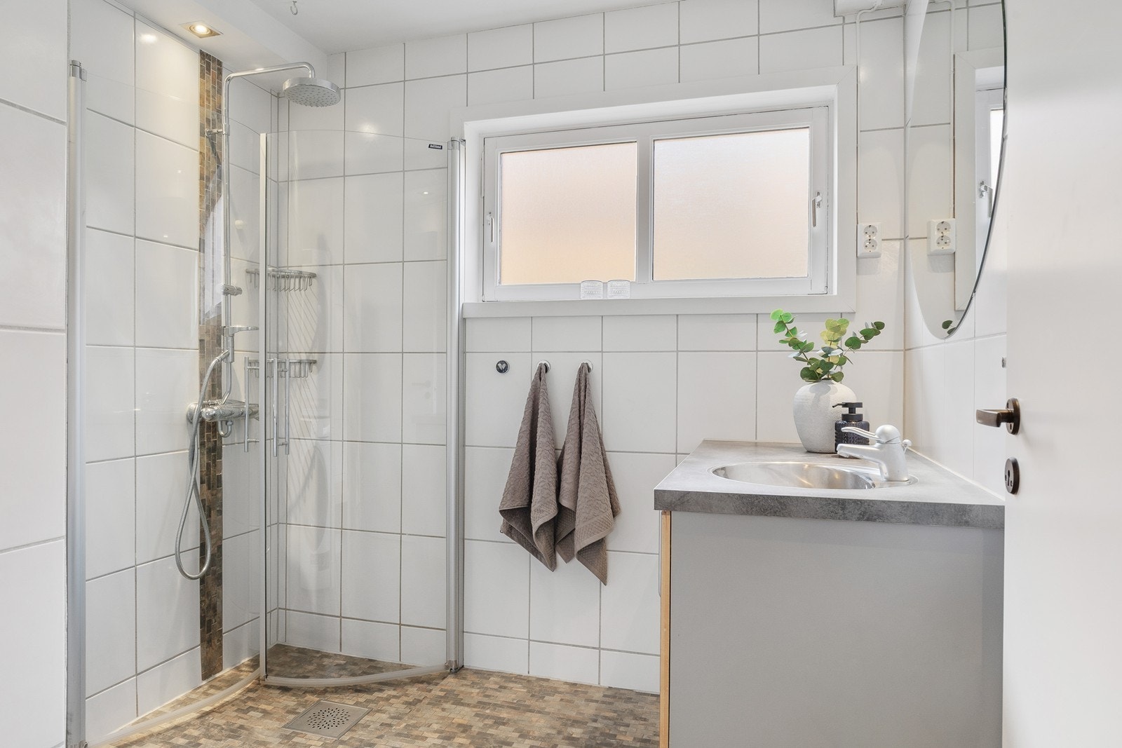 Dusjhjørne med innfellbare glassdører og regnfallsdusj. Vindu på badet gir både godt dagslys og naturlig ventilasjon Galleribilde