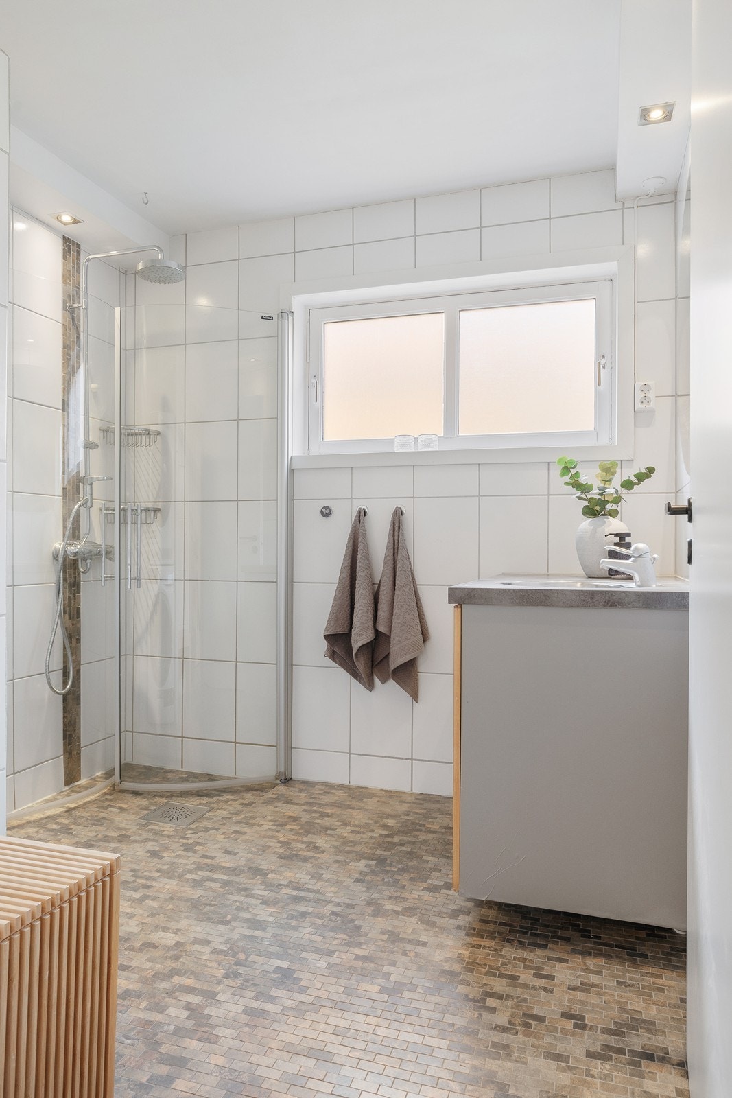 Helfliset bad med varmekabler i gulv og downlights i deler av himling Galleribilde