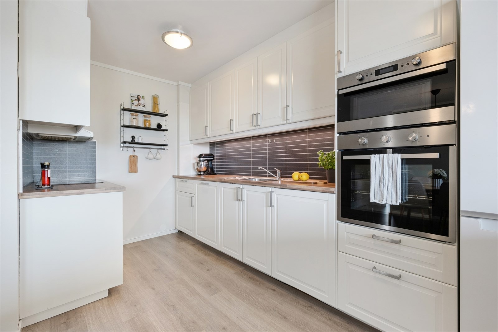 Kjøkkenet er tidløst innredet med hvite, profilerte fronter og trefarget benkeplate i laminat. Et stort og godt kjøkken hvor man har rikelig med skap- og skuffeplass, samt gode arbeidsflater på benk. Galleribilde