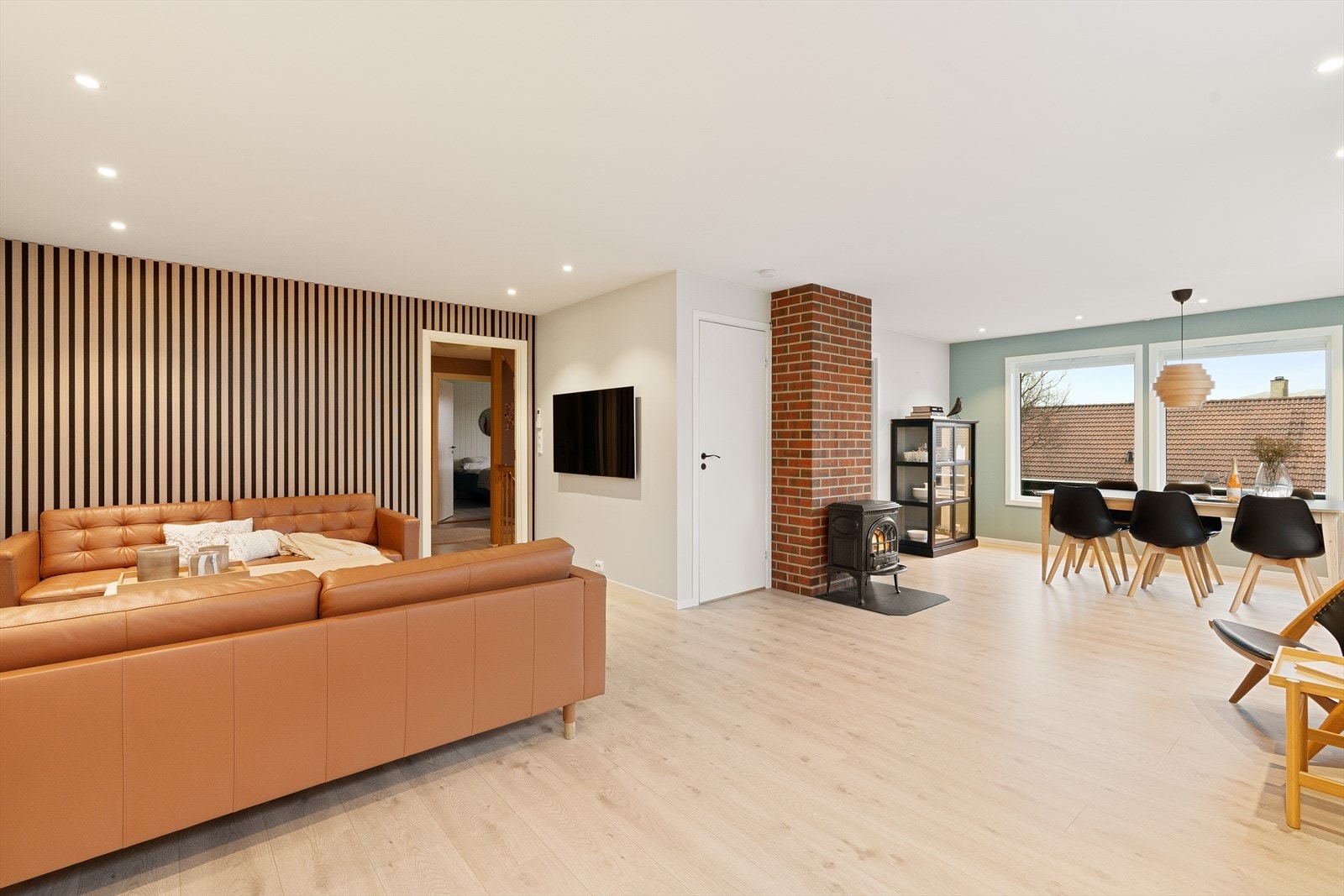 Lys og luftig stue med fin kontrastvegg m/ eikespiler Galleribilde