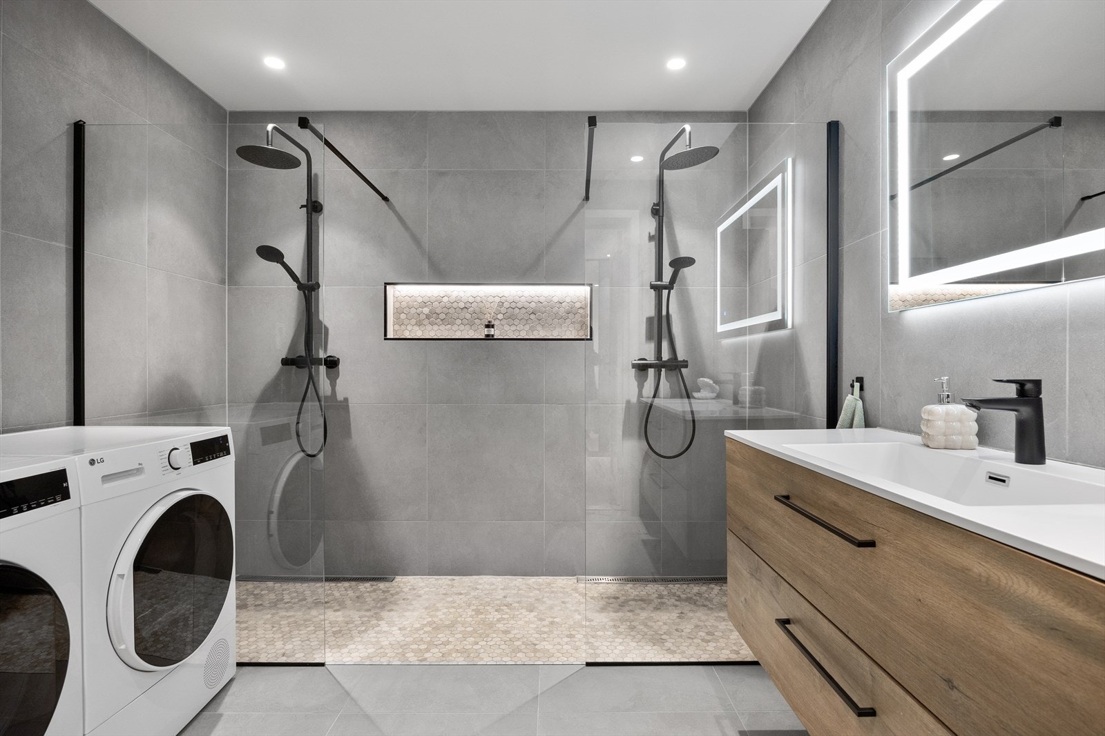 Badet er innredet med nedfelt servant, vegghengt toalett, dusjløsning med to dusjsoner og opplegg for vaskemaskin. Galleribilde