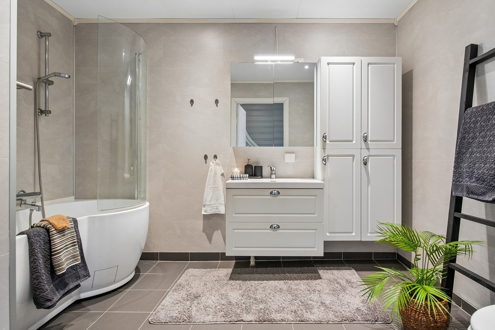 Badet ble oppgradert i 2017 med fliser på gulv, baderomsplater på veggene og servant med underskap. Galleribilde