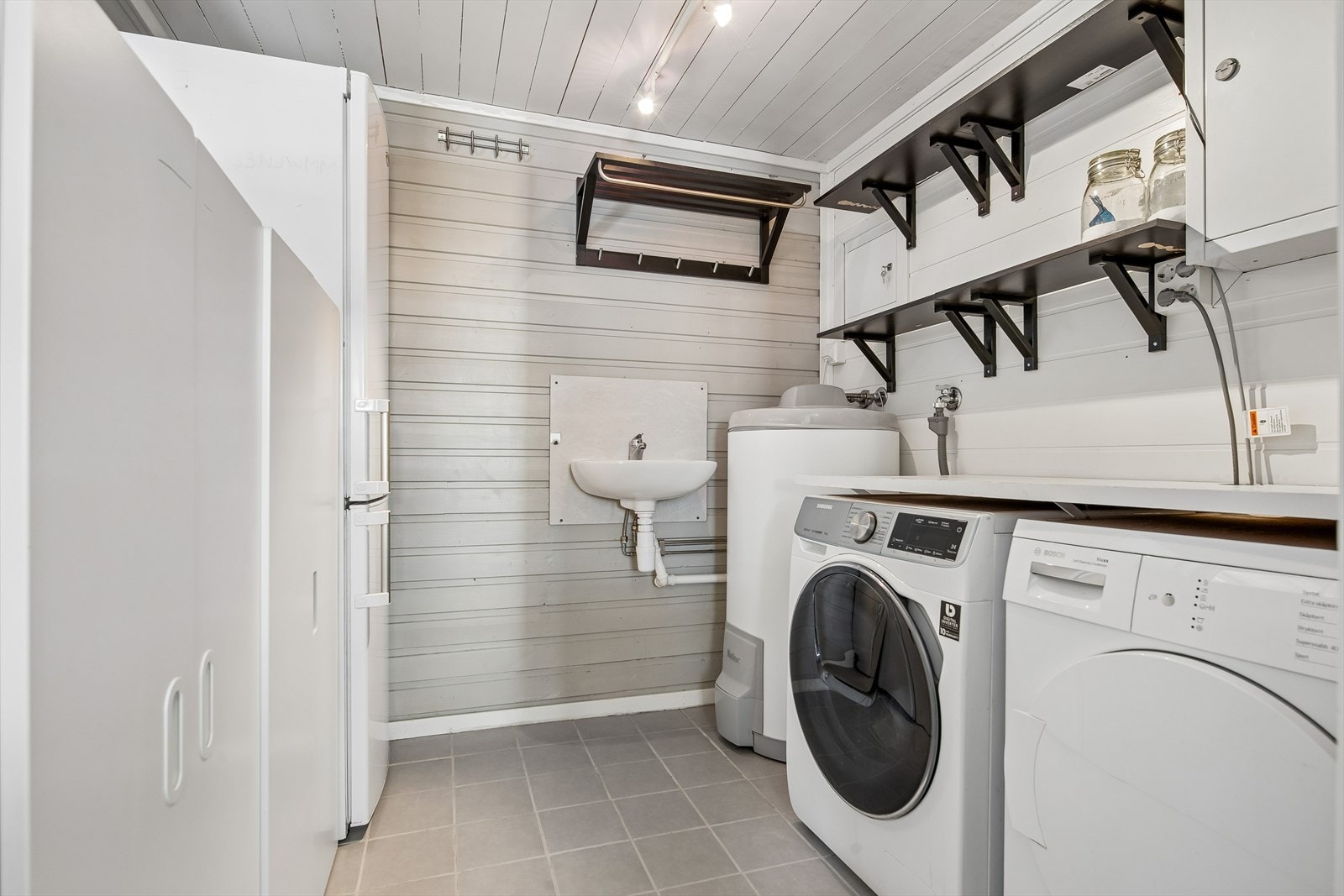 Praktisk vaskerom med gulvvarme. Her er varmtvannsberederen fra 2017 og sikringsskapet plassert. Galleribilde