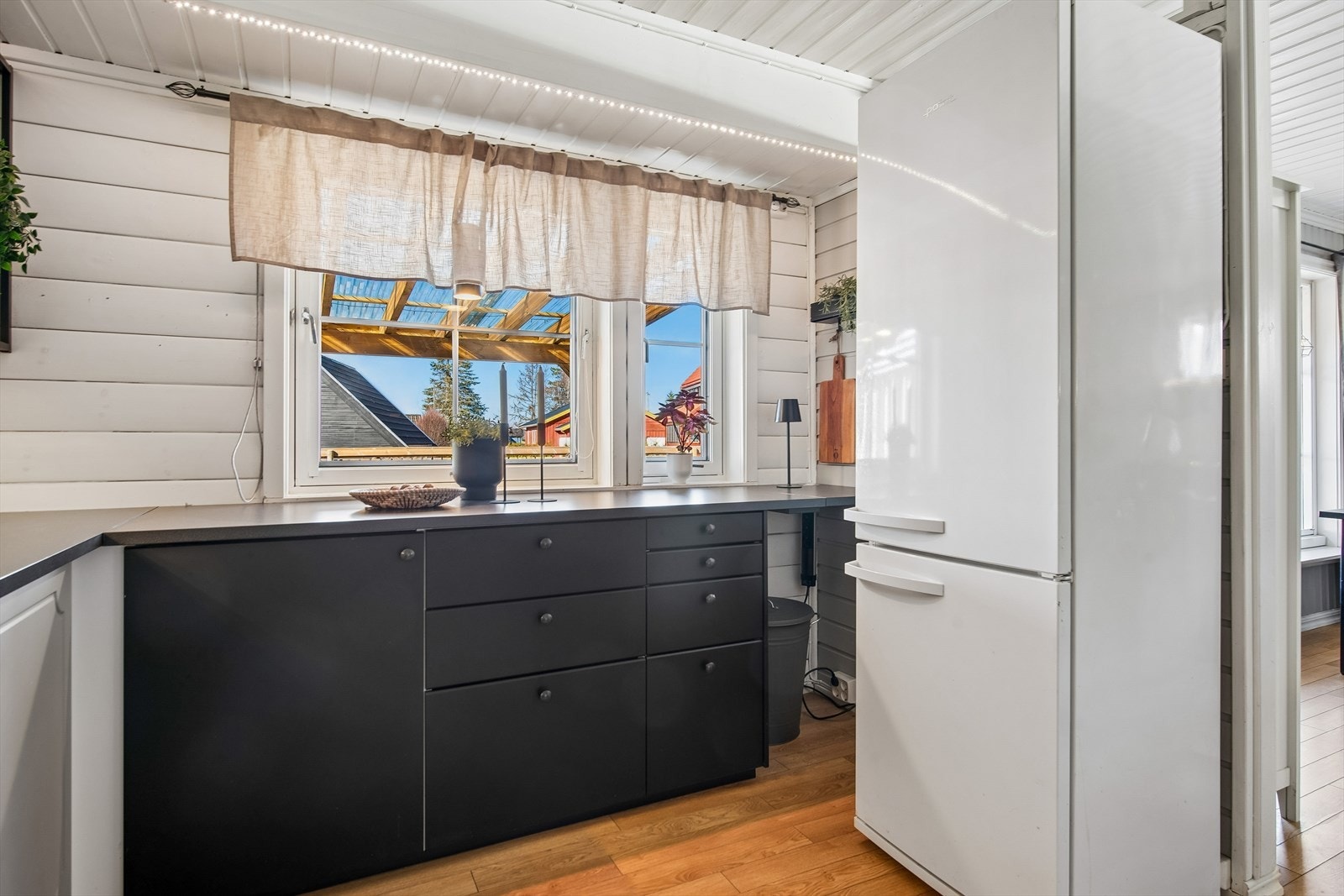 Praktisk arbeidsområde med belysning og flislagt felt over benken. Det er tilrettelagt for frittstående hvitevarer. Galleribilde