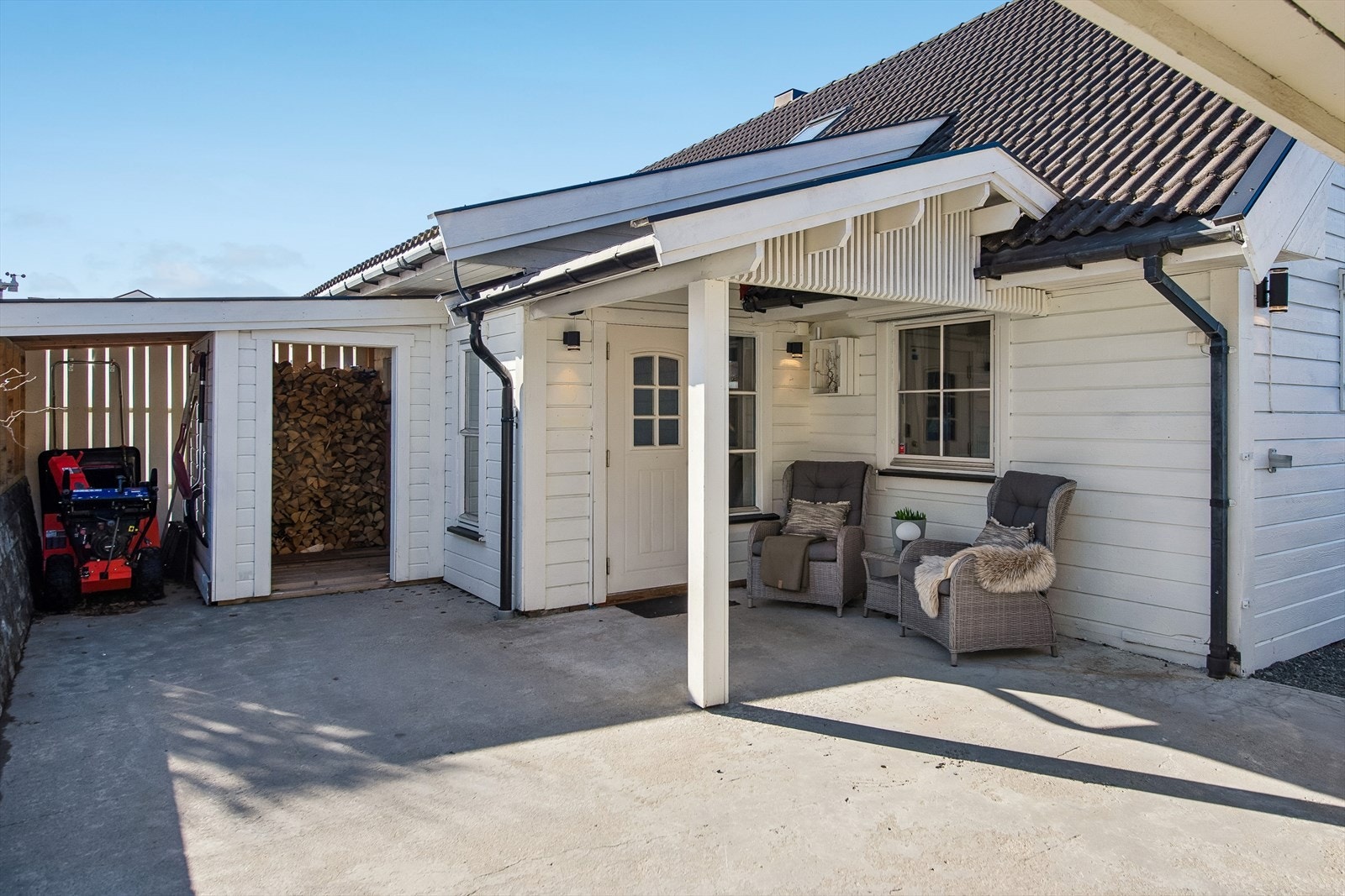 Ved inngangspartiet er det en overbygget uteplass og en praktisk, nybygd vedbod fra 2024. Galleribilde