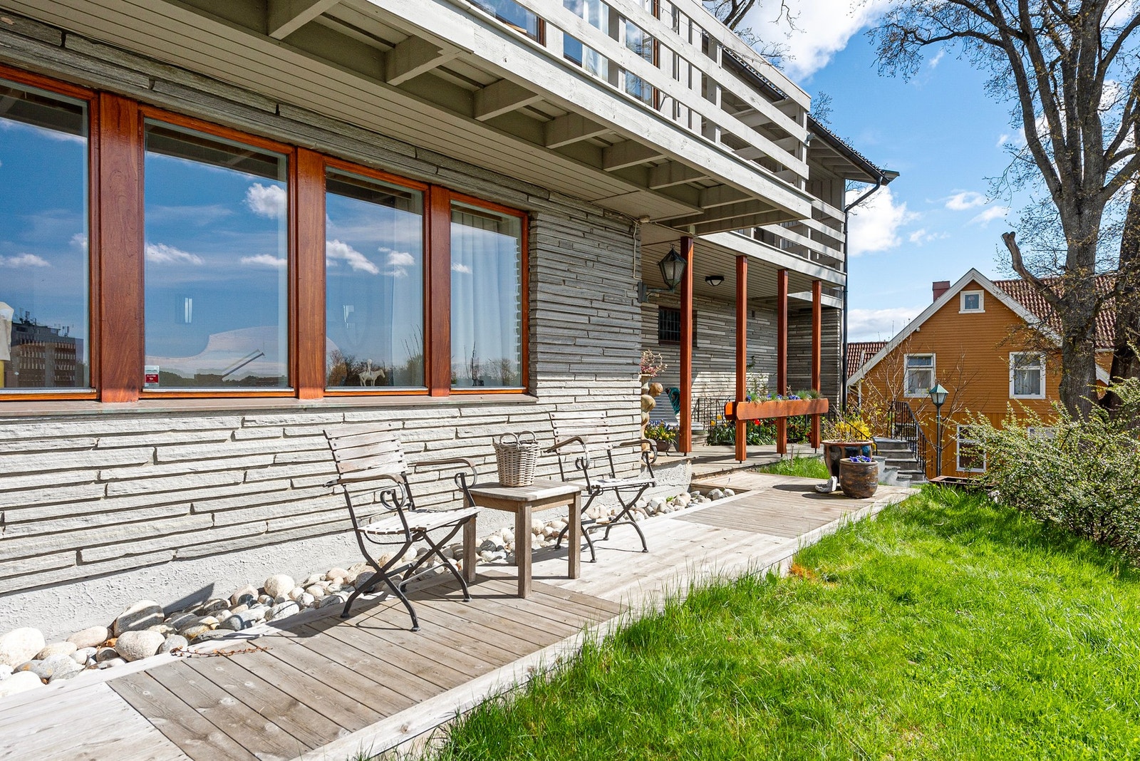 En uformell og hyggelig uteplass ved inngangspartiet, perfekt for korte pauser, kaffe i solen eller å ønske gjester velkommen Galleribilde