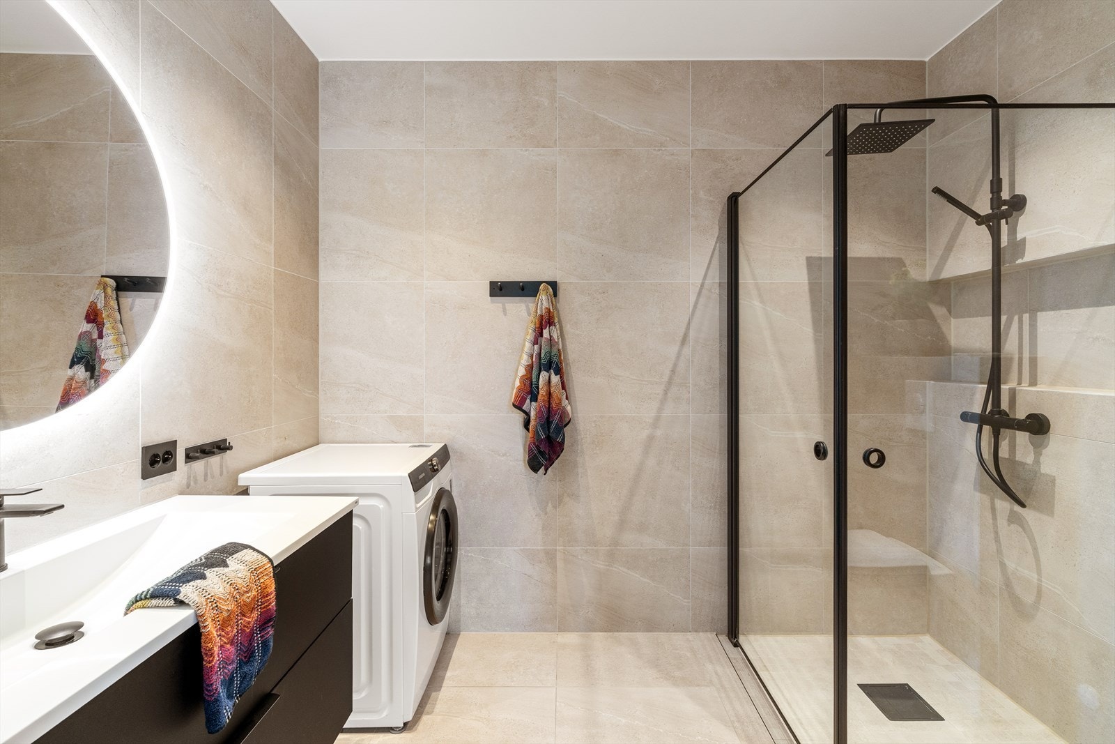 Moderne helfliset bad med vannbåren gulvvarme og opplegg for vaskemaskin og tørketrommel. Galleribilde