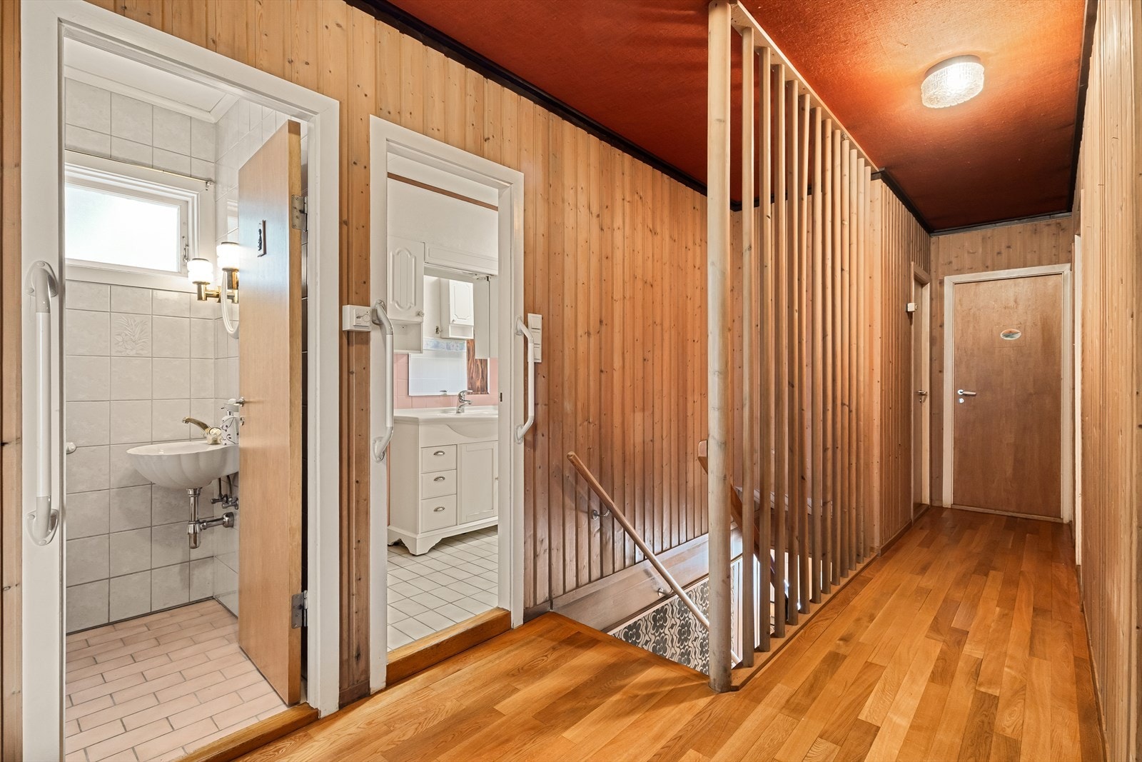 Gang i hovedplan med dører til toalett, bad, garderobe/kott og to soverom Galleribilde