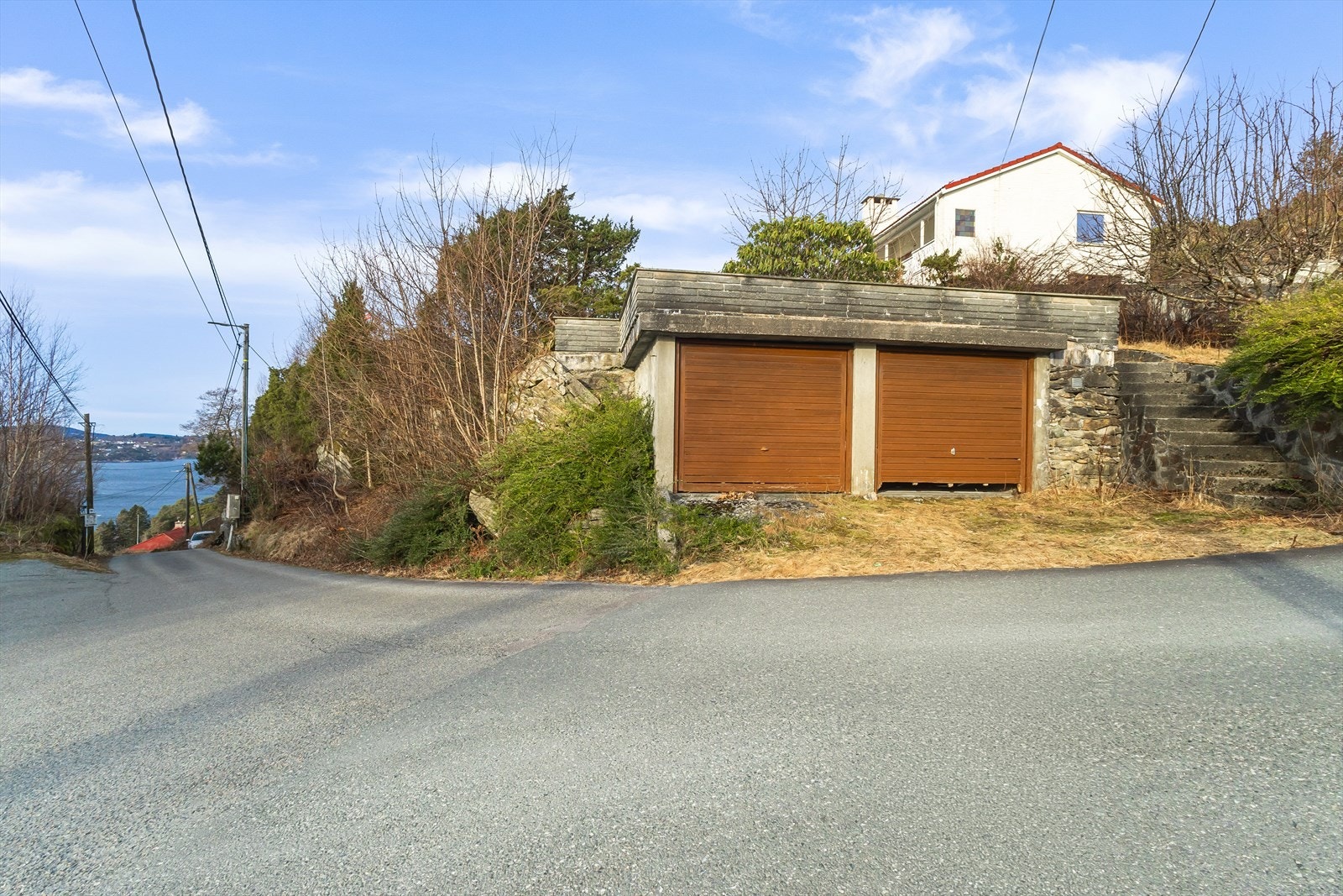 Dobbelgarasje med trapper opp til eiendommen Galleribilde