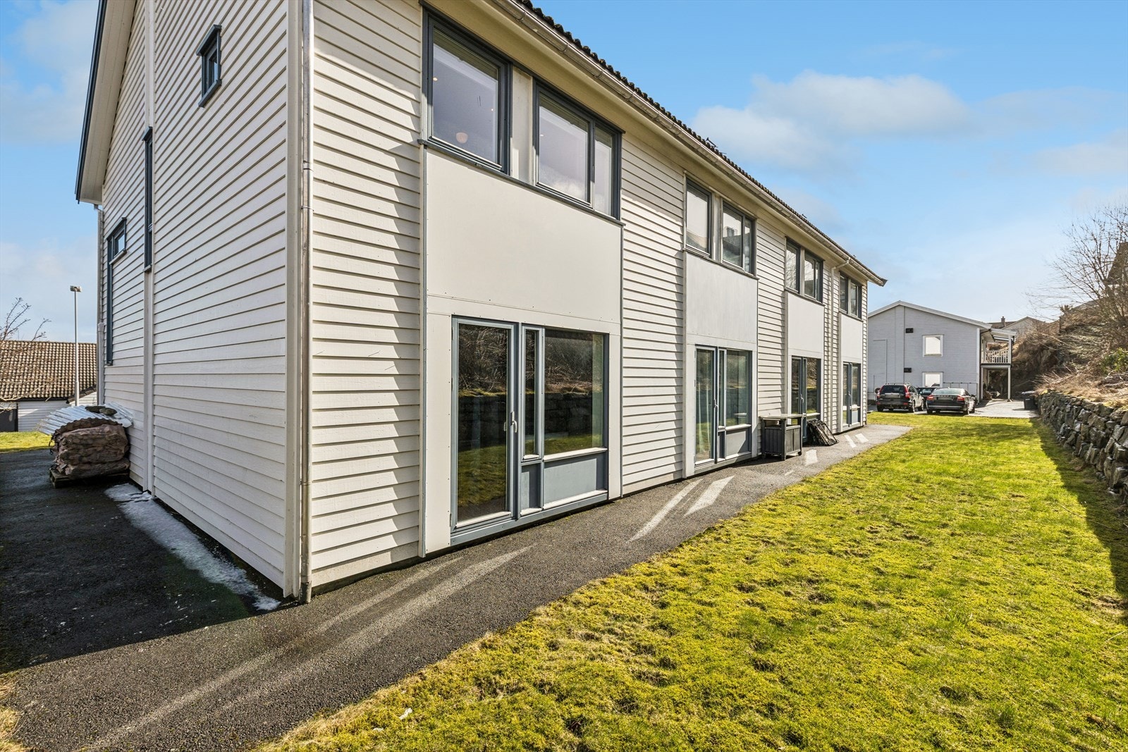 Fellestomt bestående av asfalterte p-plasser, gangstier og gressplen. Galleribilde