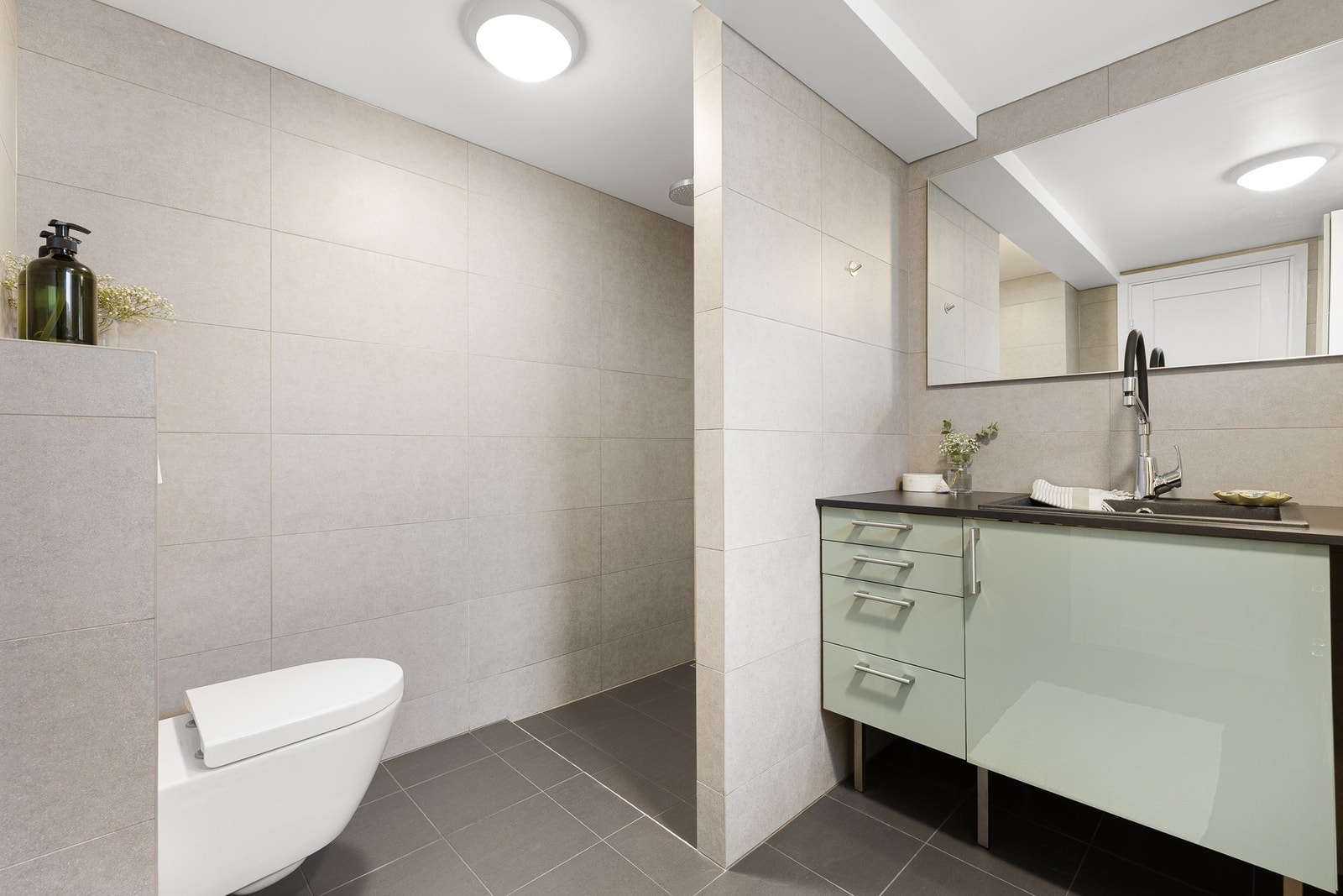 Badet er utstyrt med vegghengt WC, opplegg for vaskemaskin og flislagt dusjnisje. Takstmannen har gitt tilstandsgrad 1. Galleribilde