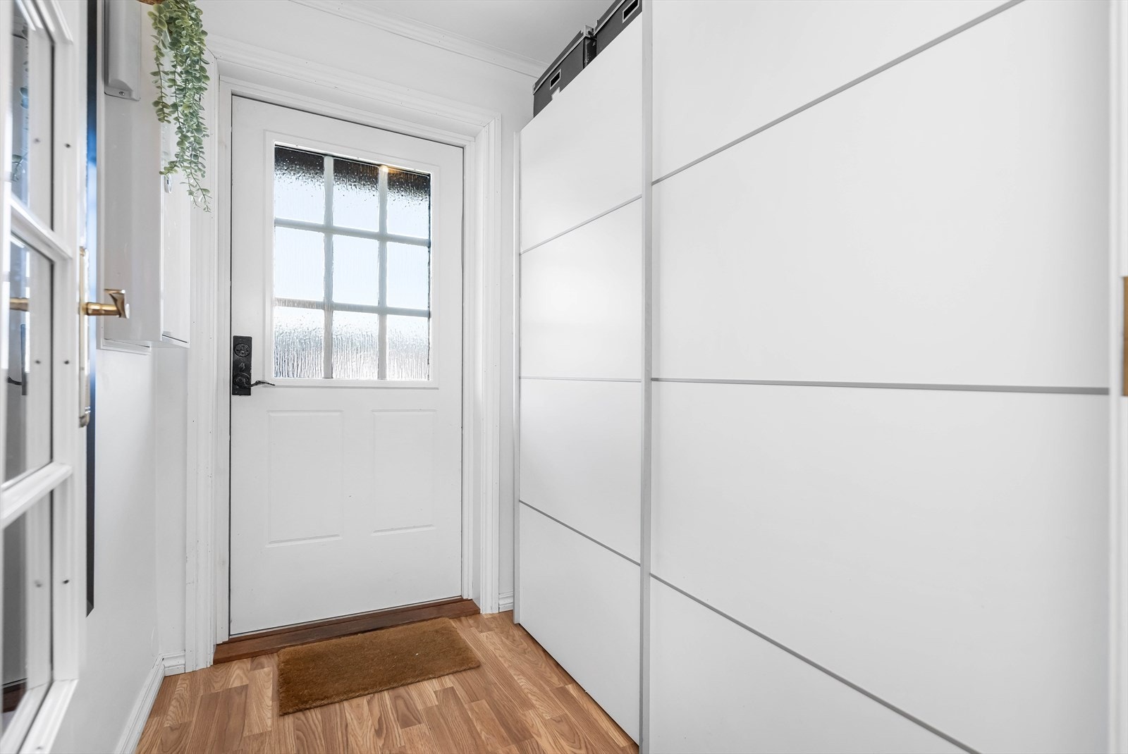 Fra det overbygde og skjermede inngangspartiet kommer en inn i boligens entre/gang. Her er det rikelig plass for klær og sko. Galleribilde