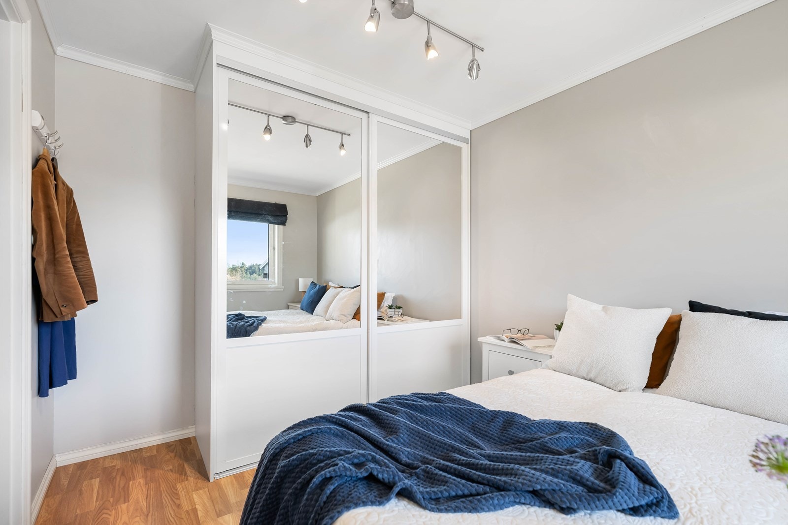 Rikelig med plass til klær og oppbevaring i en lekker garderobe med skyvedører. Galleribilde