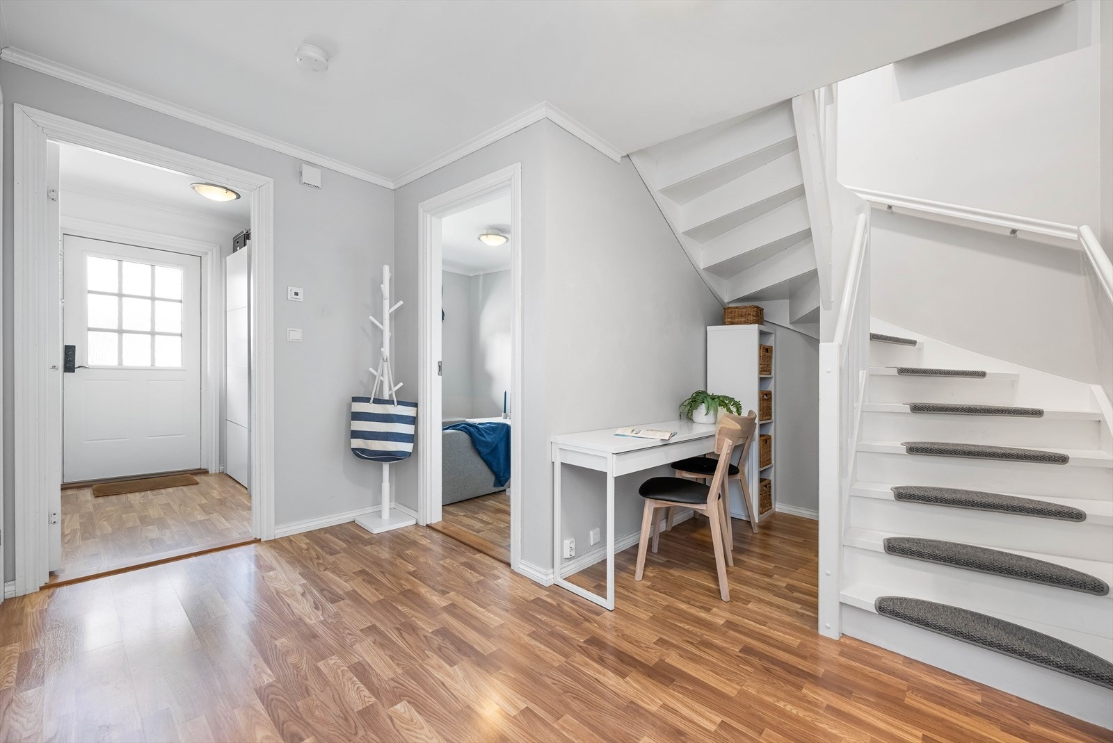 Hallen er romslig med inngang til fleste av etasjen rom. Rommets utforming har gitt plass for en kontorplass ved trappen. Galleribilde