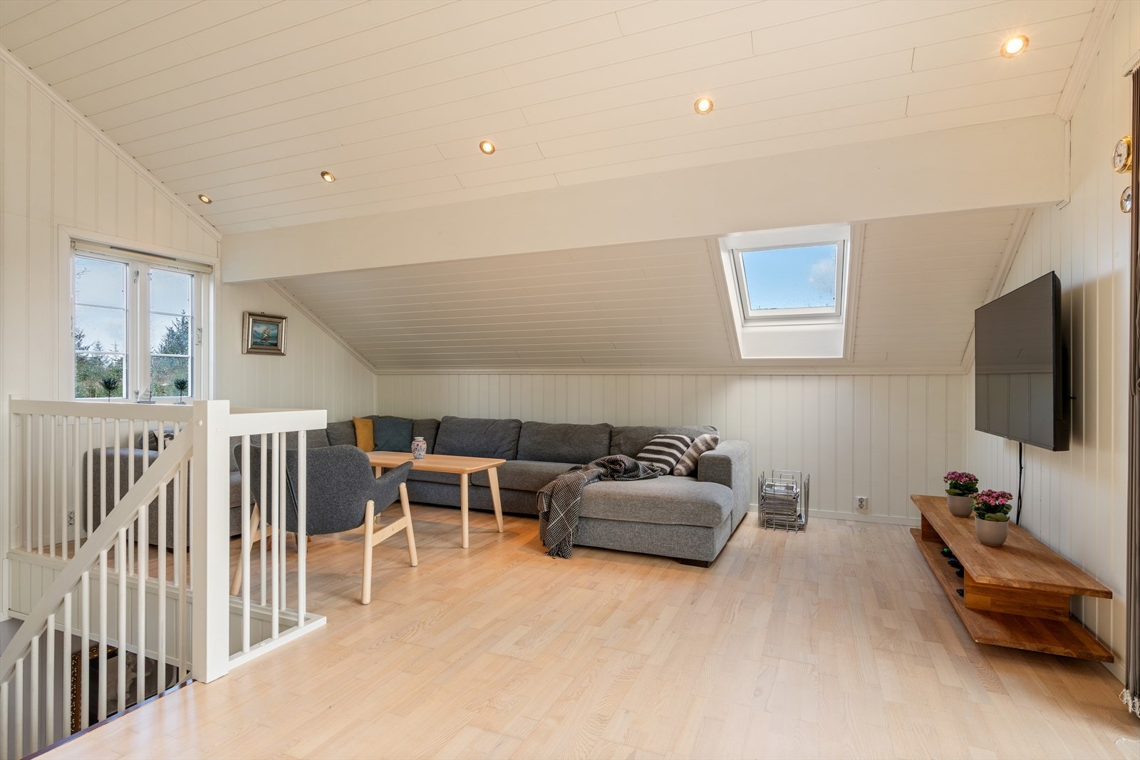 Loftstuen med TV-seksjon og takvindu som slipper inn mye lys. Galleribilde