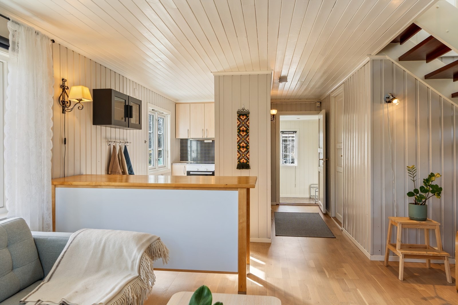 Åpen og lys stue med gjennomgående parkett og panel. Naturlig overgang til kjøkken og gang Galleribilde