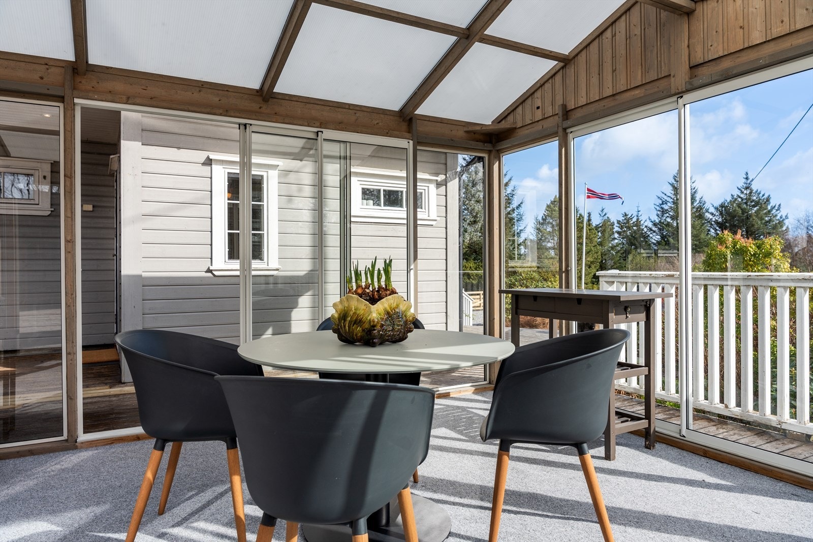 Hagestuen innenfra - lys og luftig med utsyn til hagen. Perfekt for måltider ute selv når været ikke spiller helt på lag. Galleribilde