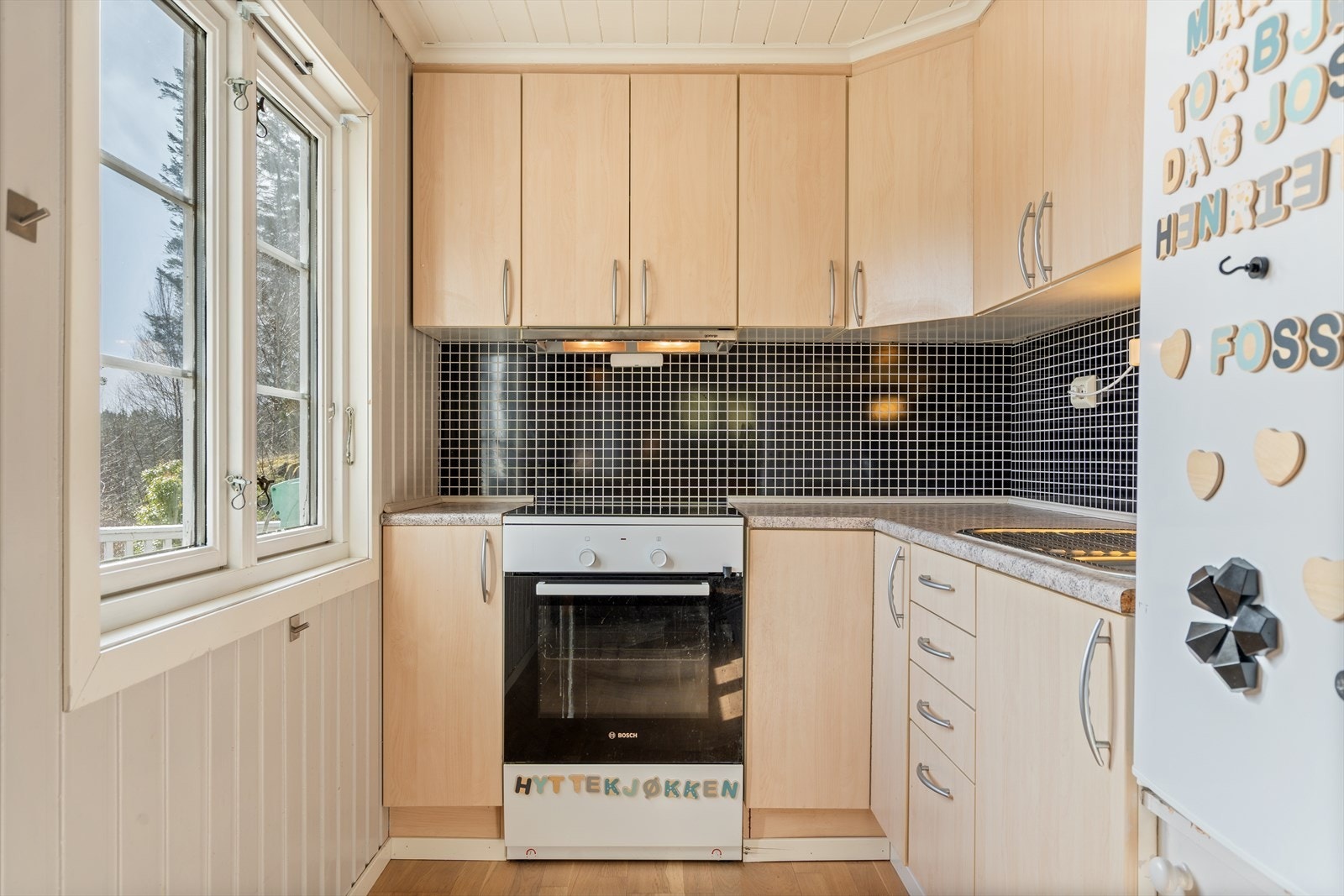 Praktisk og funksjonelt hyttekjøkken med utsyn til naturen. Hvitevarer følger salget. Galleribilde