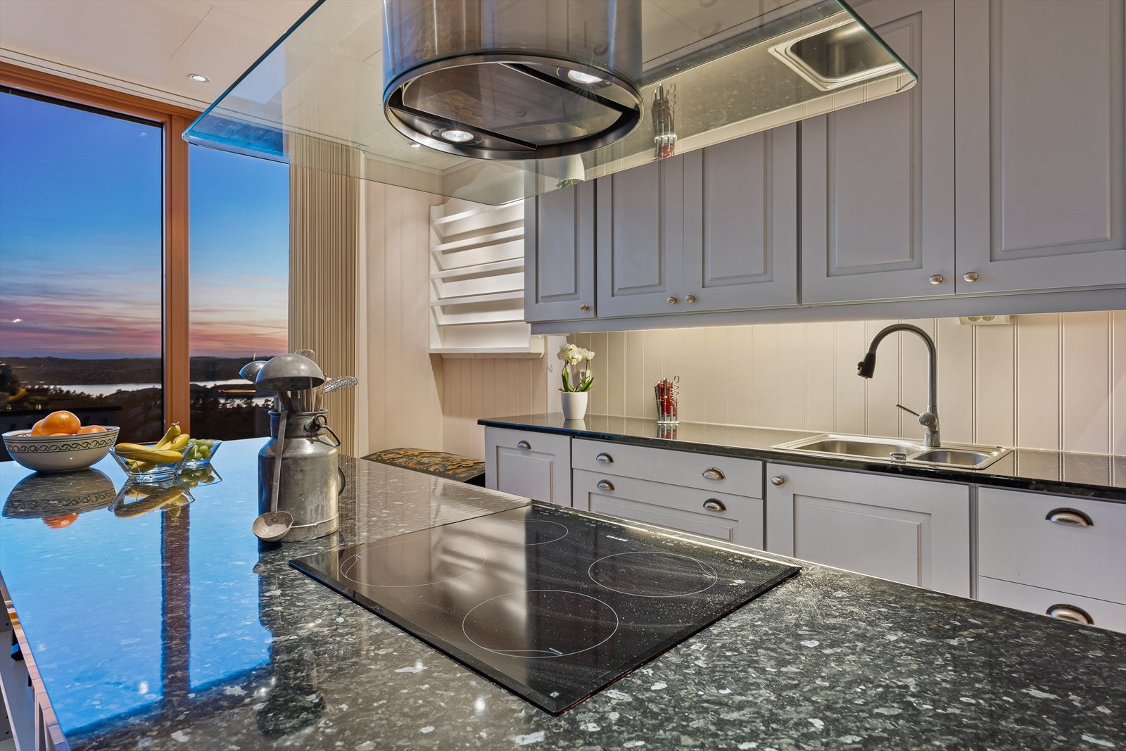 Moderne kjøkken med elegant benkeplate og vakker utsikt mot solnedgangen. Perfekt for matlaging og sosiale sammenkomster Galleribilde